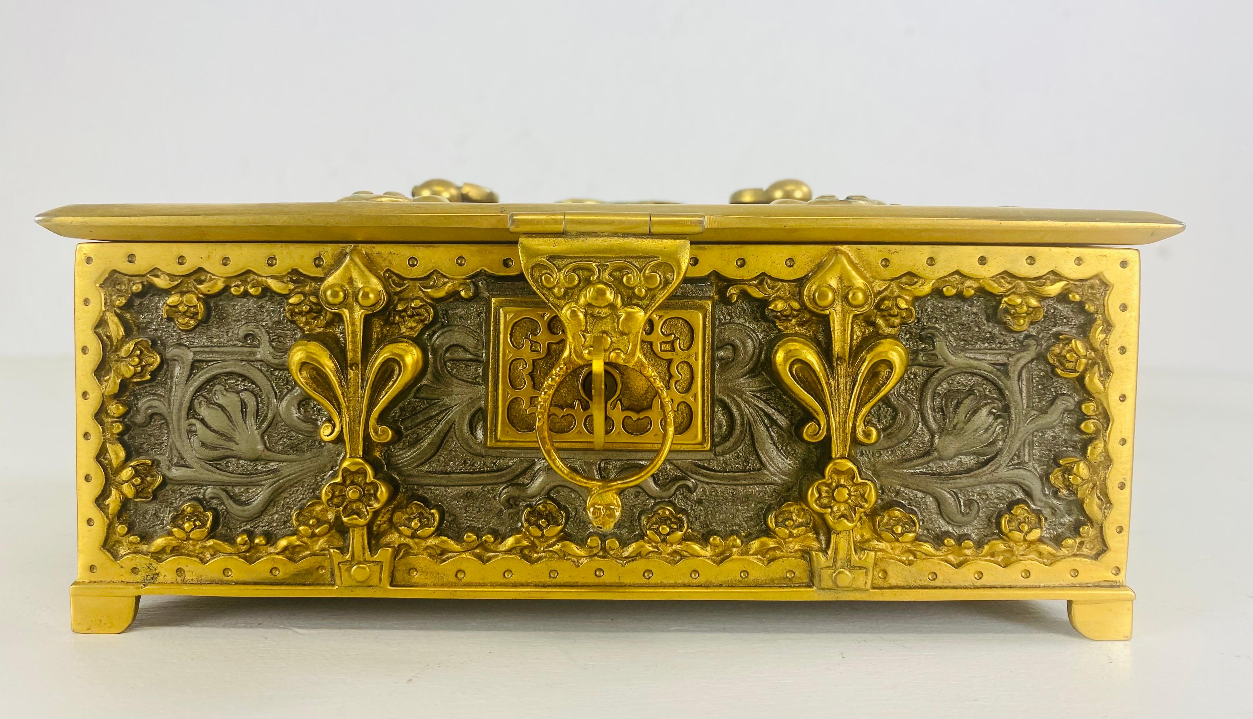 This is a mid 20th century beautifully handcrafted Art Nouveau polished steel and brass trinket box or lock box. This box has beautifully handcrafted polished steel art Nouveau flowers and vines surrounded by a brass edge. The box features its