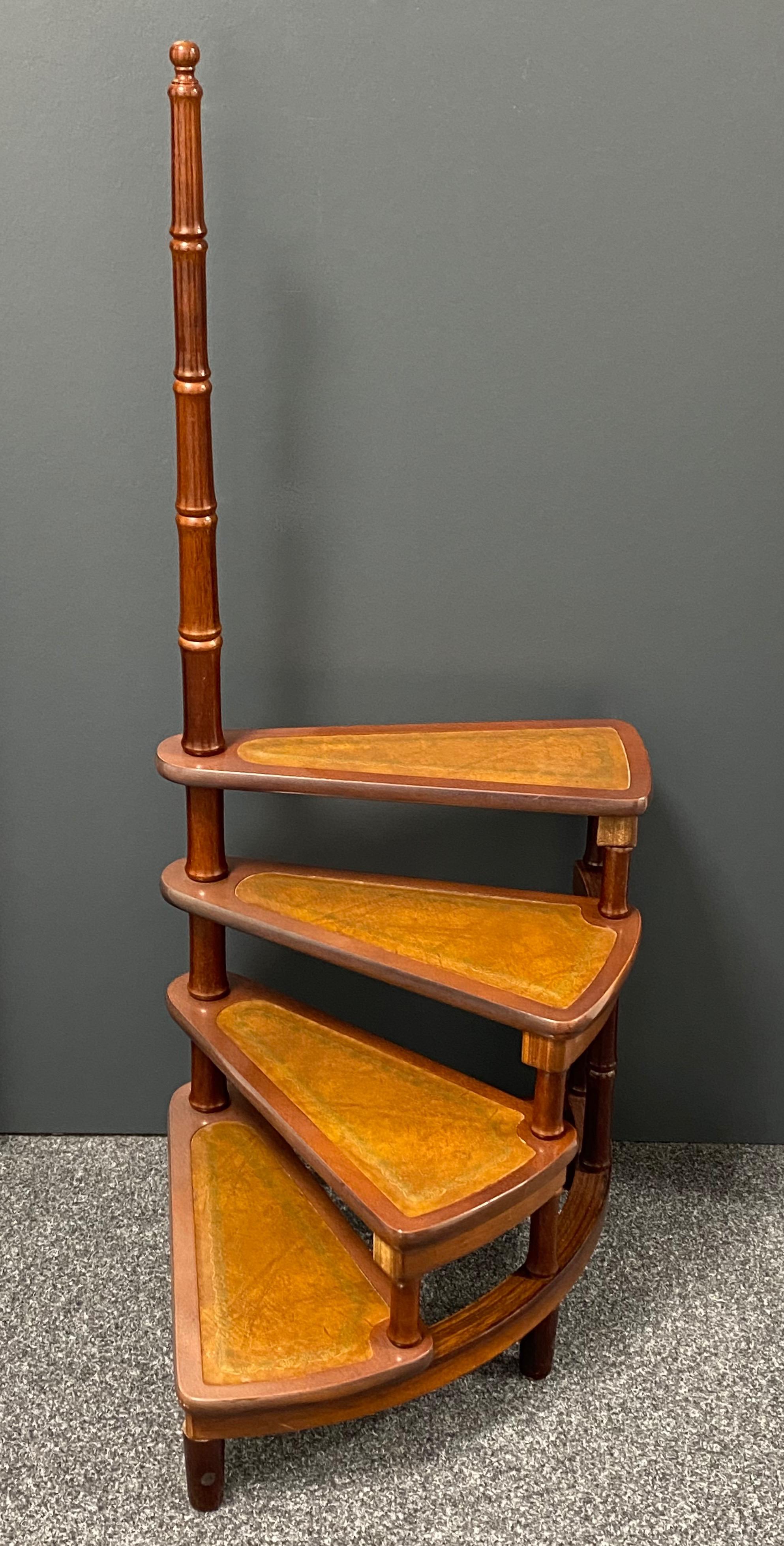 Created in Germany circa 1960 and standing on turned legs, the tall circular step ladder features four stairs rolled around a turned, central post embellished with a decorative wood finial at the pediment. Each step is upholstered with the original
