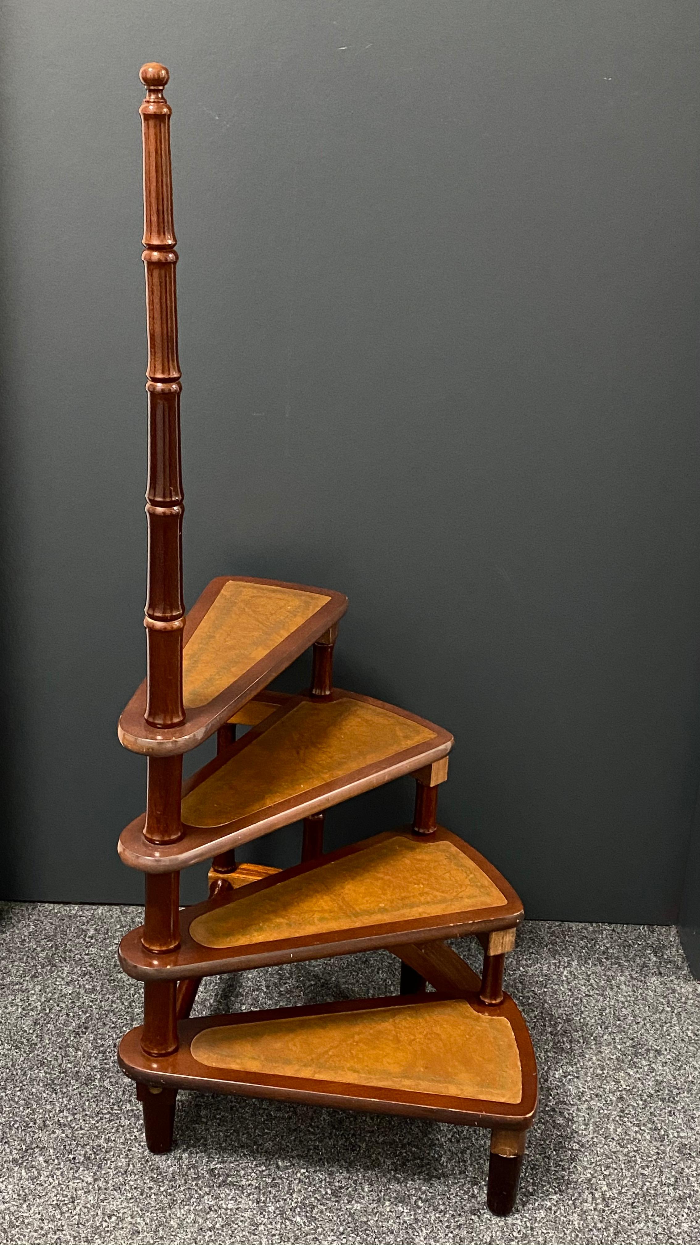 Created in Germany circa 1960 and standing on turned legs, the tall circular step ladder features four stairs rolled around a turned, central post embellished with a decorative wood finial at the pediment. Each step is upholstered with the original