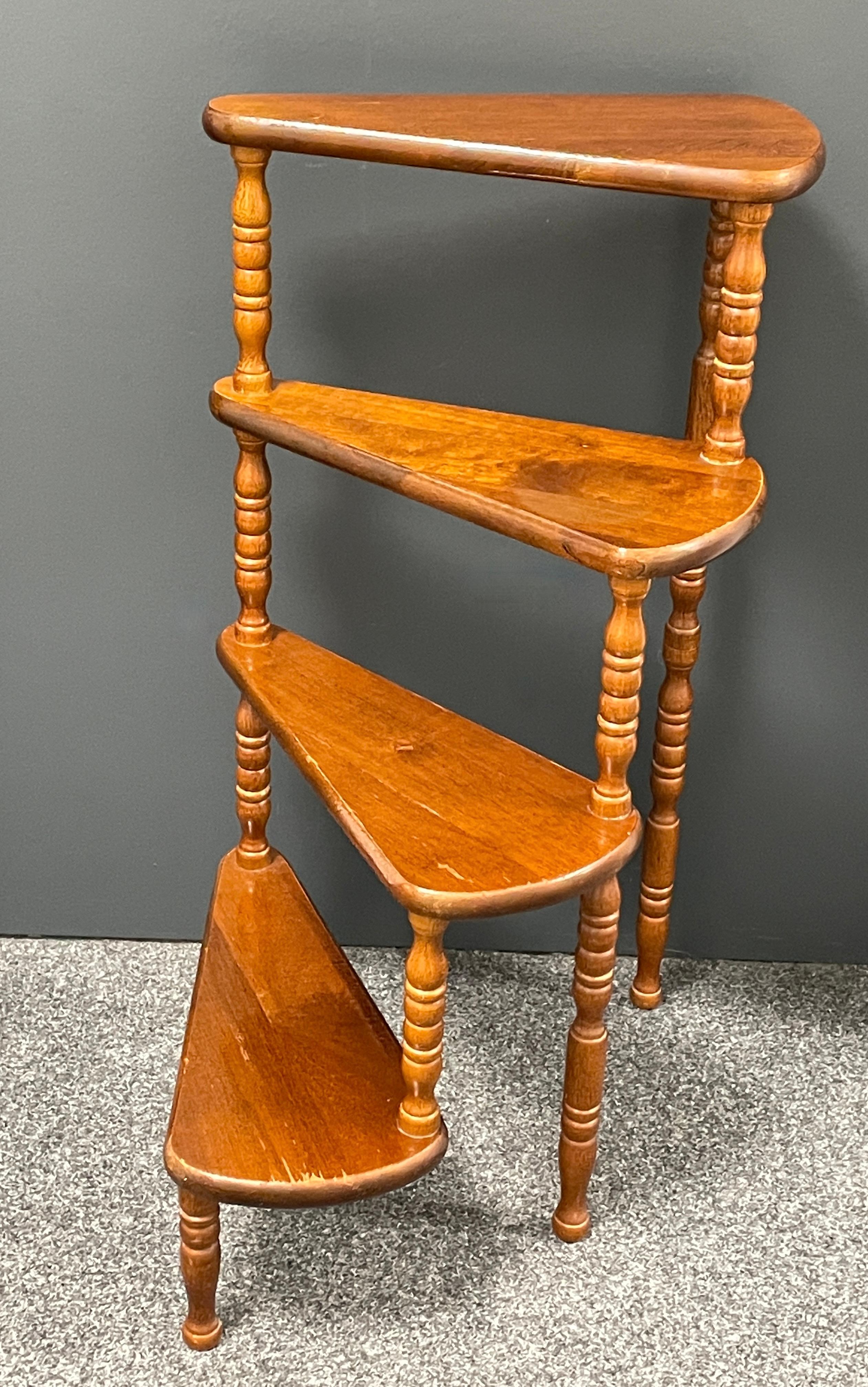 Created in Germany circa 1960s to 1970s and standing on turned legs, the circular step ladder features four stairs rolled around a turned central post. Versatile and practical, the elegant library essential is in very good used condition with a nice