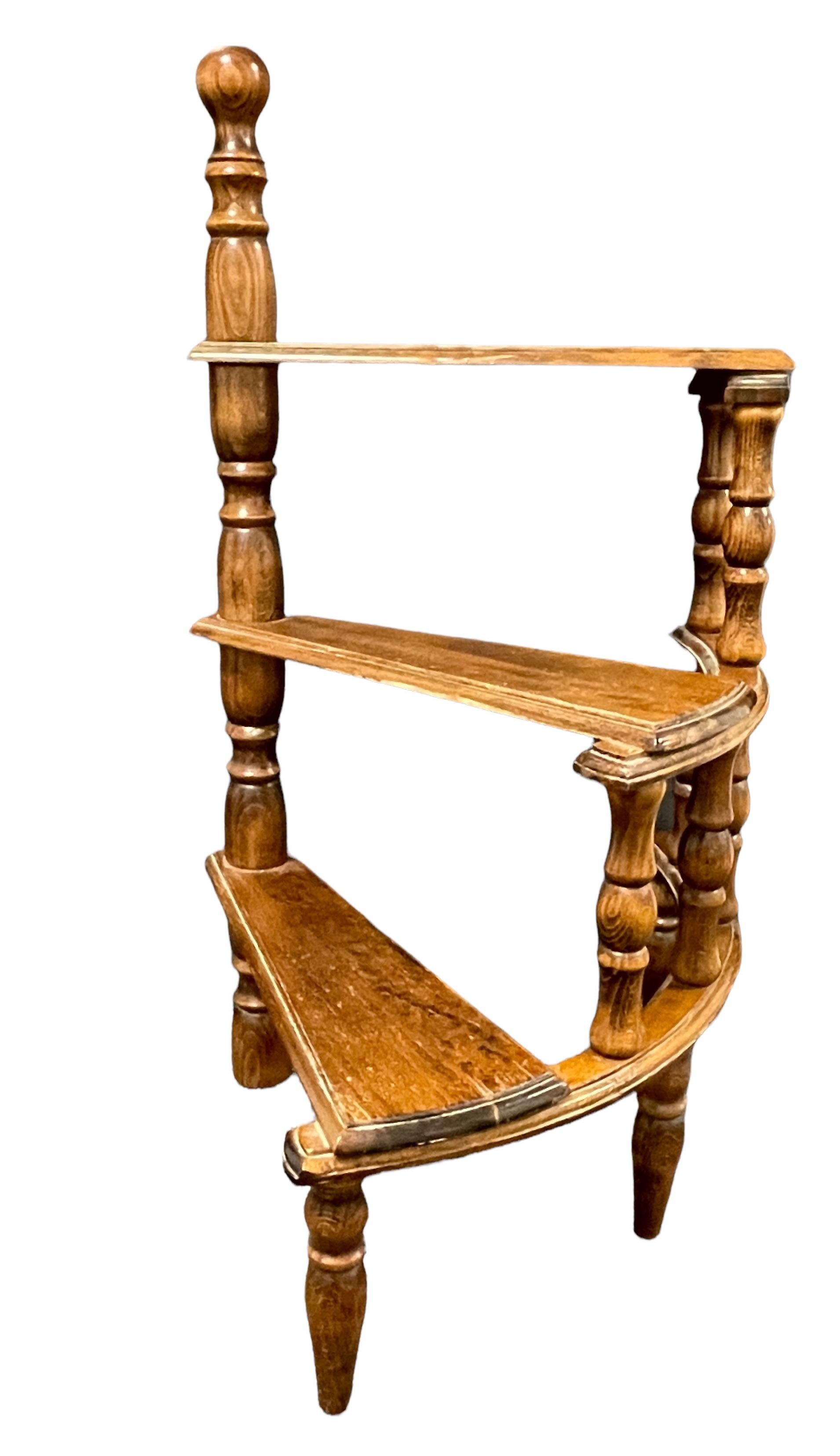 Created in Germany circa 1960 and standing on turned legs, the circular step ladder features three stairs rolled around a turned central post. Versatile and practical, the elegant library essential is in very good used condition with a nice patina.