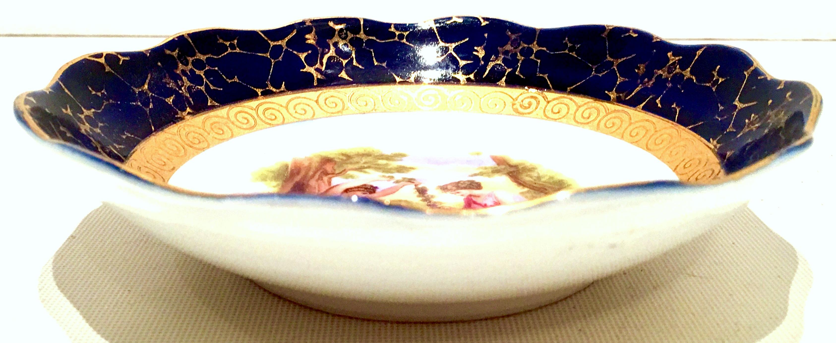 Mid-20th century German Sevres style porcelain hand painted cobalt and 24-karat gold detail dish. Features two women and a child outdoors. Signed on the underside Echt Cobalt-Martinroda. Signed front left by the artist.
