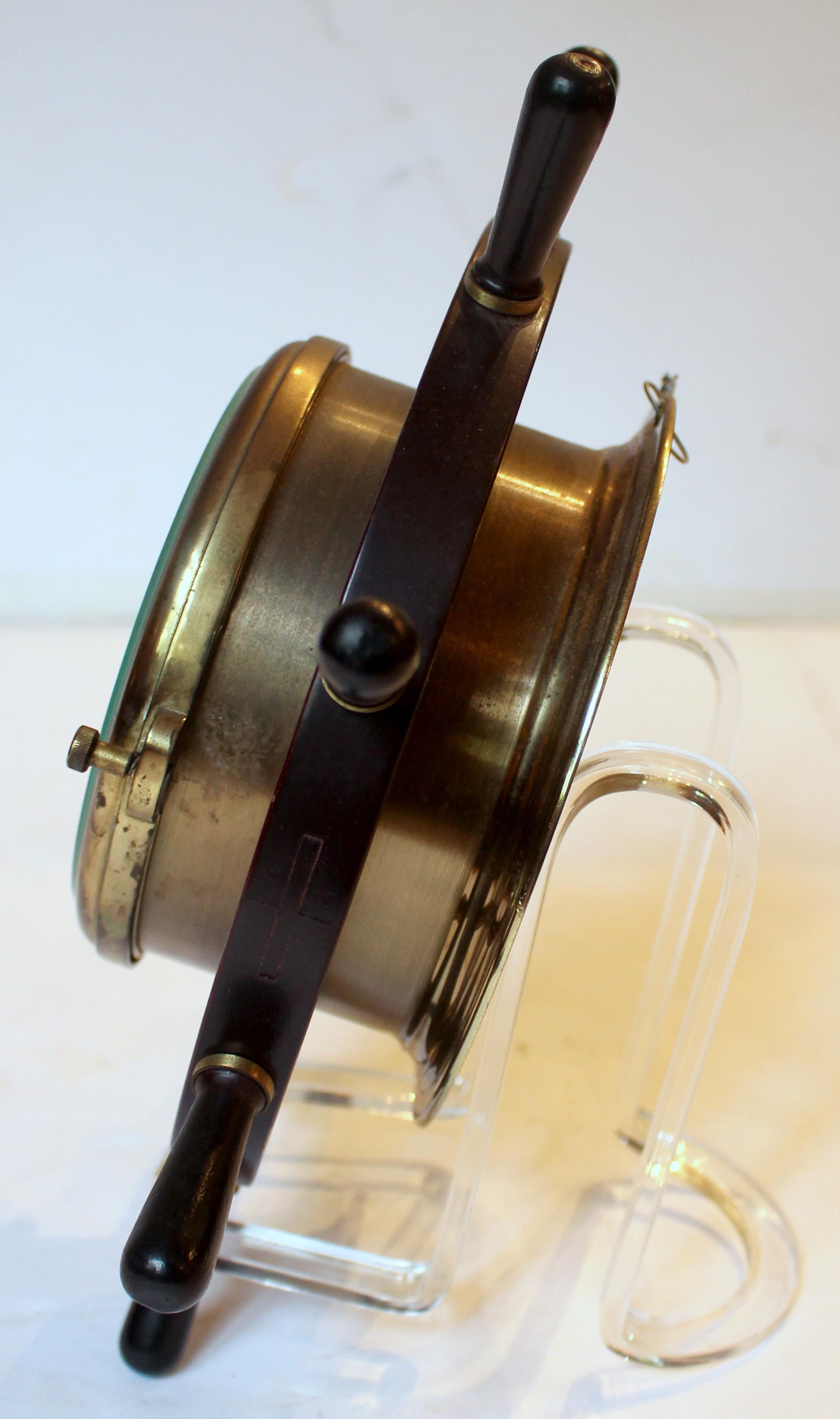 Mid-20th century ship's clock by Schatz, Germany. handsome brass, mahogany & ebony in the form of a ship's wheel. Bevelled glass set in locking bezel. Double bell strike. Runs 8 days. 6