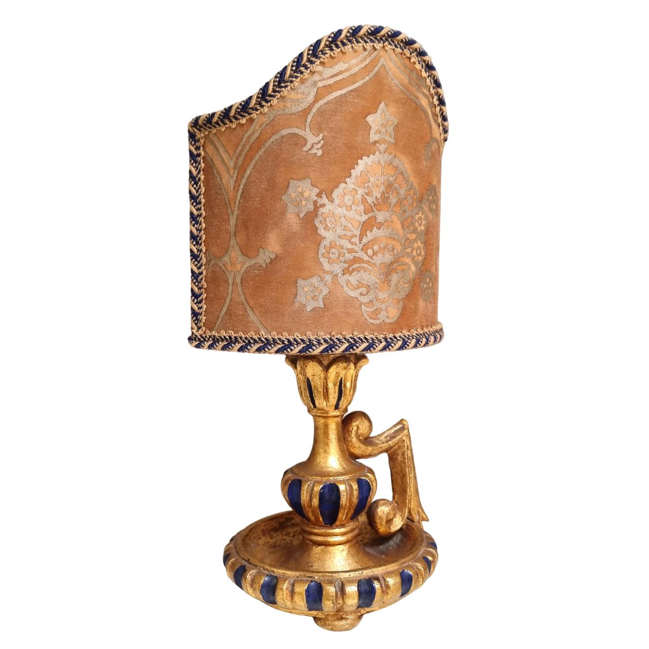 This is an amazing Italian carved wood candlestick with handle converted to table lamp, mid-20th century, painted with blue lacquer and finished with original gold leaf gilding. Newly wired and in perfect working condition.
The lampshade is new