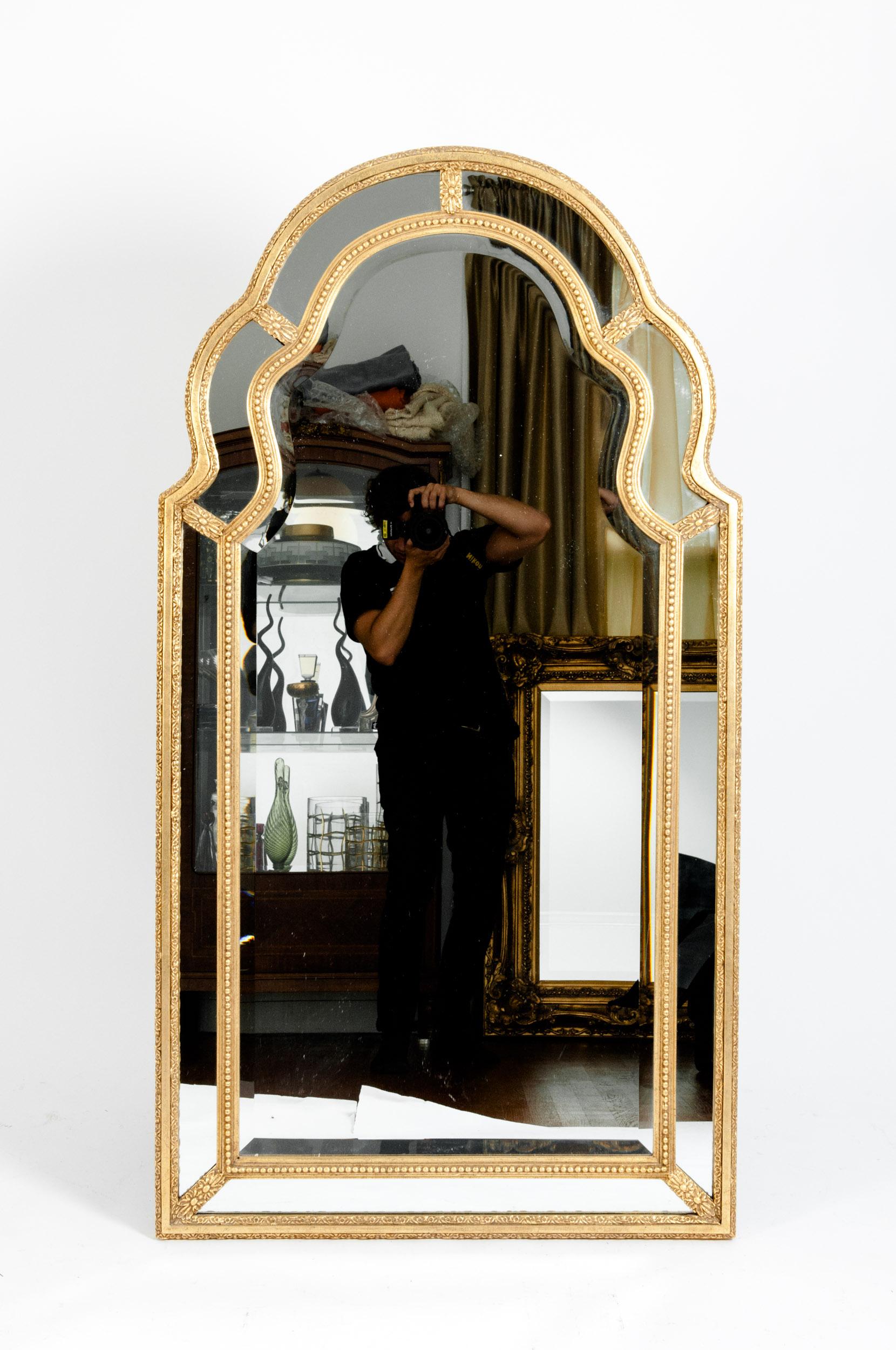 Mid-20th century giltwood frame arched top beveled hanging wall mantel mirror. The mirror is in great condition with appropriate wear consistent with age / use. The mirror measure about 56 inches high x 30 inches wide.