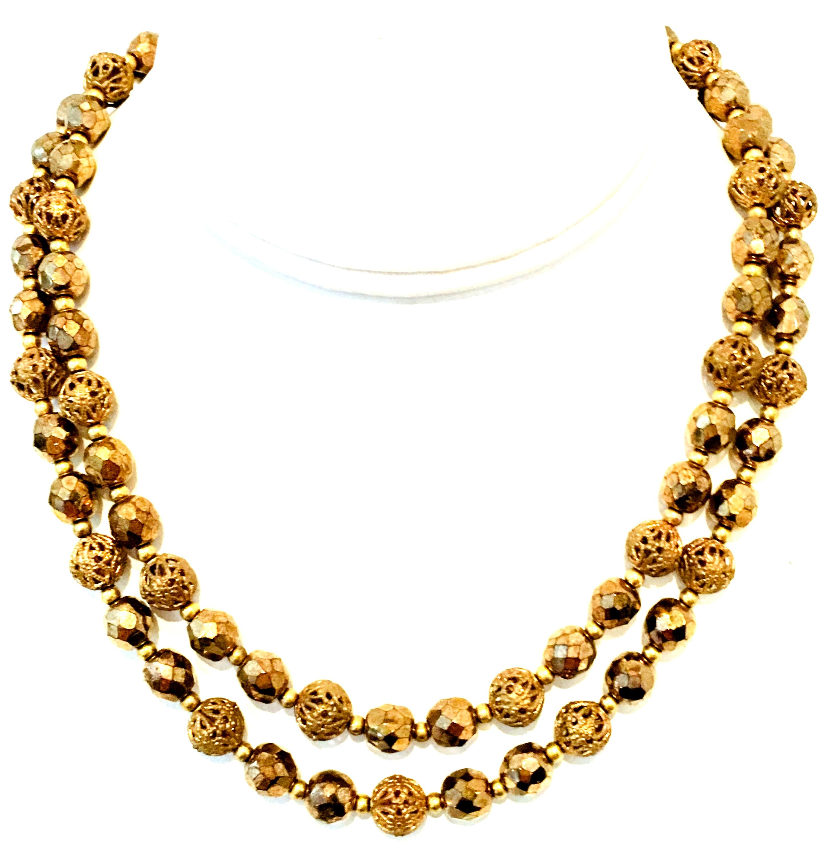 Mid- 20th Century Gold Bead Double Strand Choker Necklace. This finely crafted double strand choker necklace features cut and faceted bronze glass and gold plate metal beads with and outstanding jeweled clasp. Each bead is approximately, .25