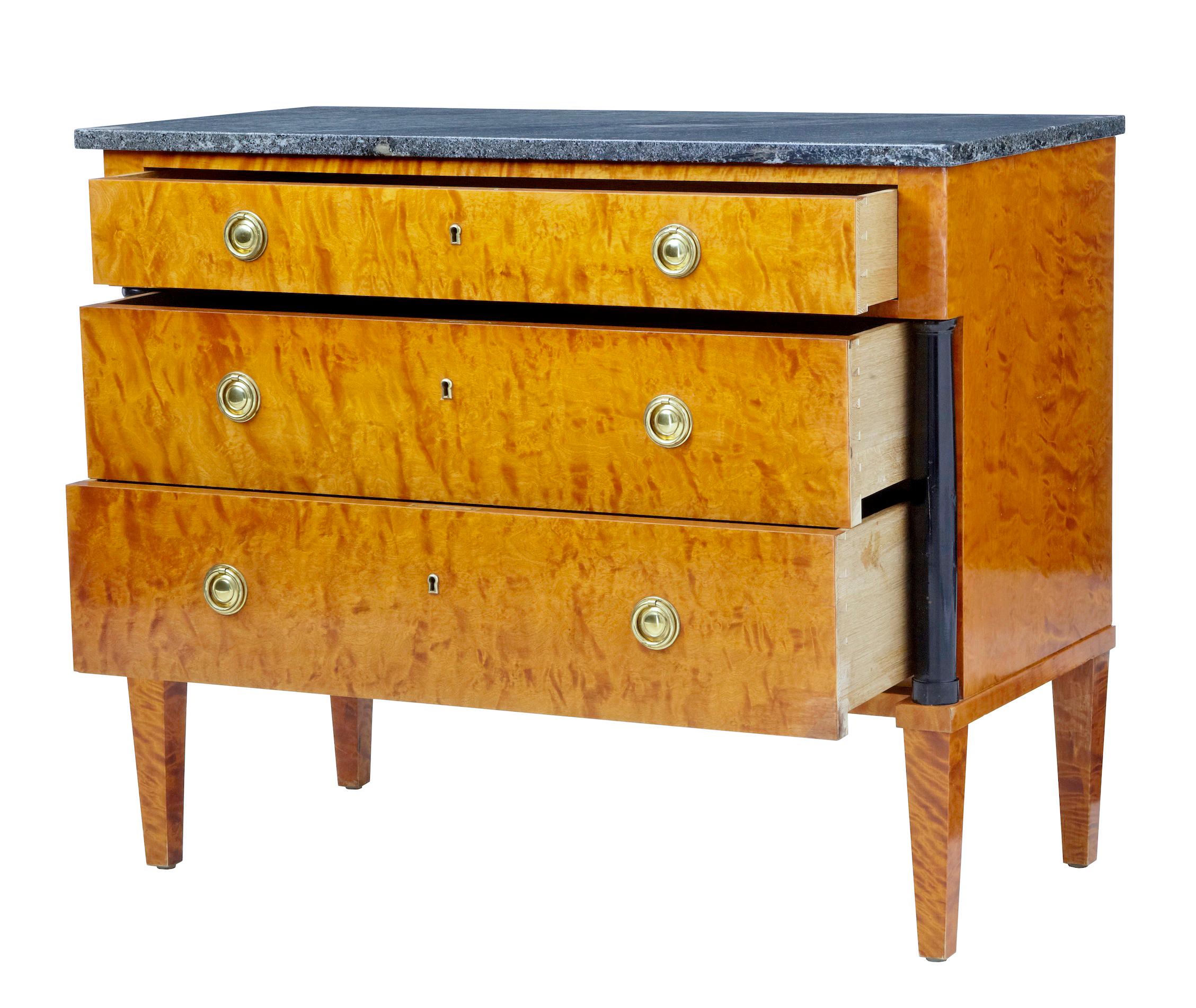 Mid-20th century golden birch marble-top chest of drawers, circa 1940.

Over sailing top with loose fitting marble. Fitted with 3 drawers fitted with brass ring handles. Standing on tapered legs. Detailed with an ebonized column each