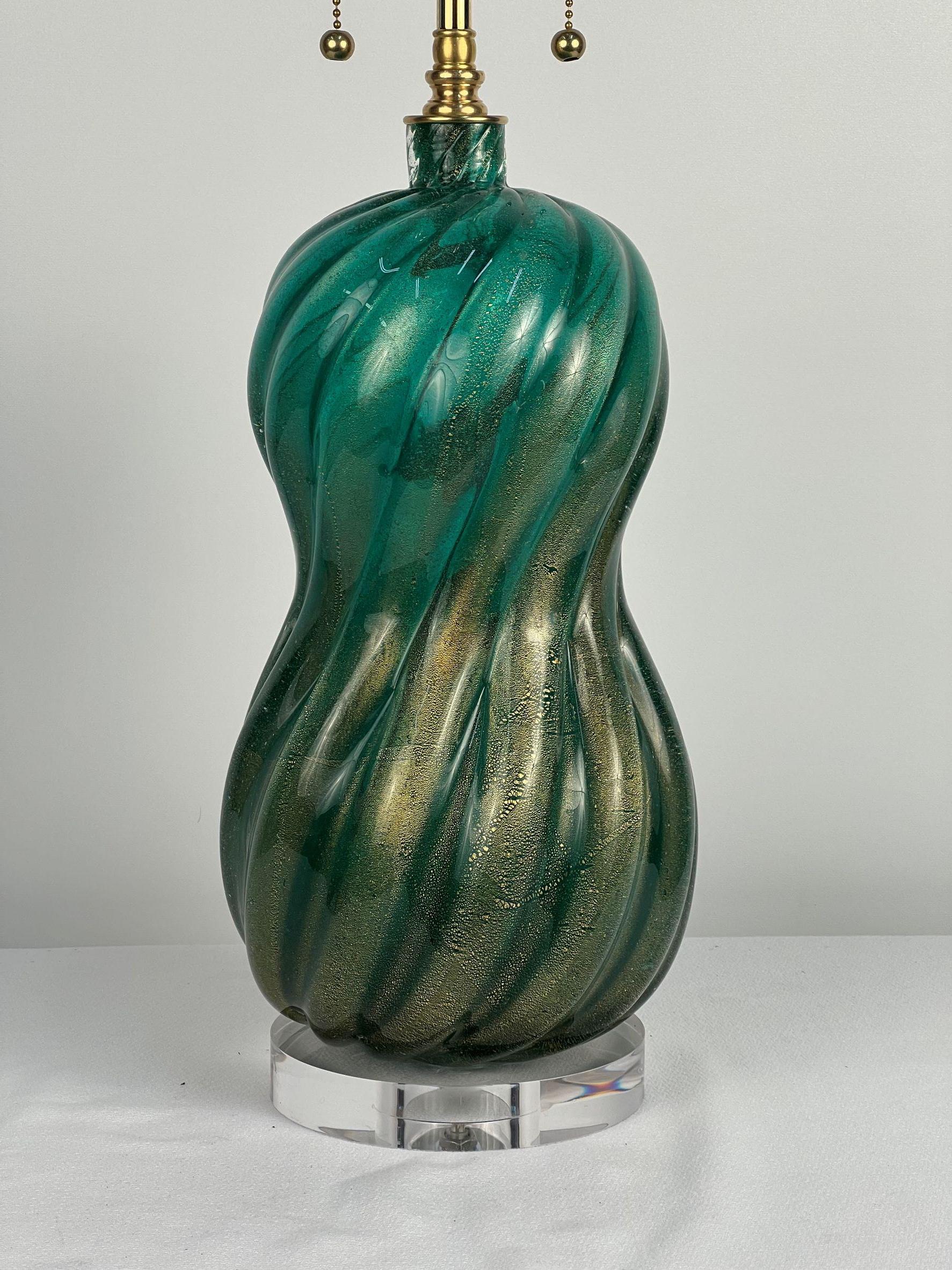  A beautiful vintage Murano swirl form lamp base featuring electric green and classic Murano gold fleck detail. This piece is so alive with a fluid mixture of green and gold. It has been freshened up with a new clear acrylic base and solid brass