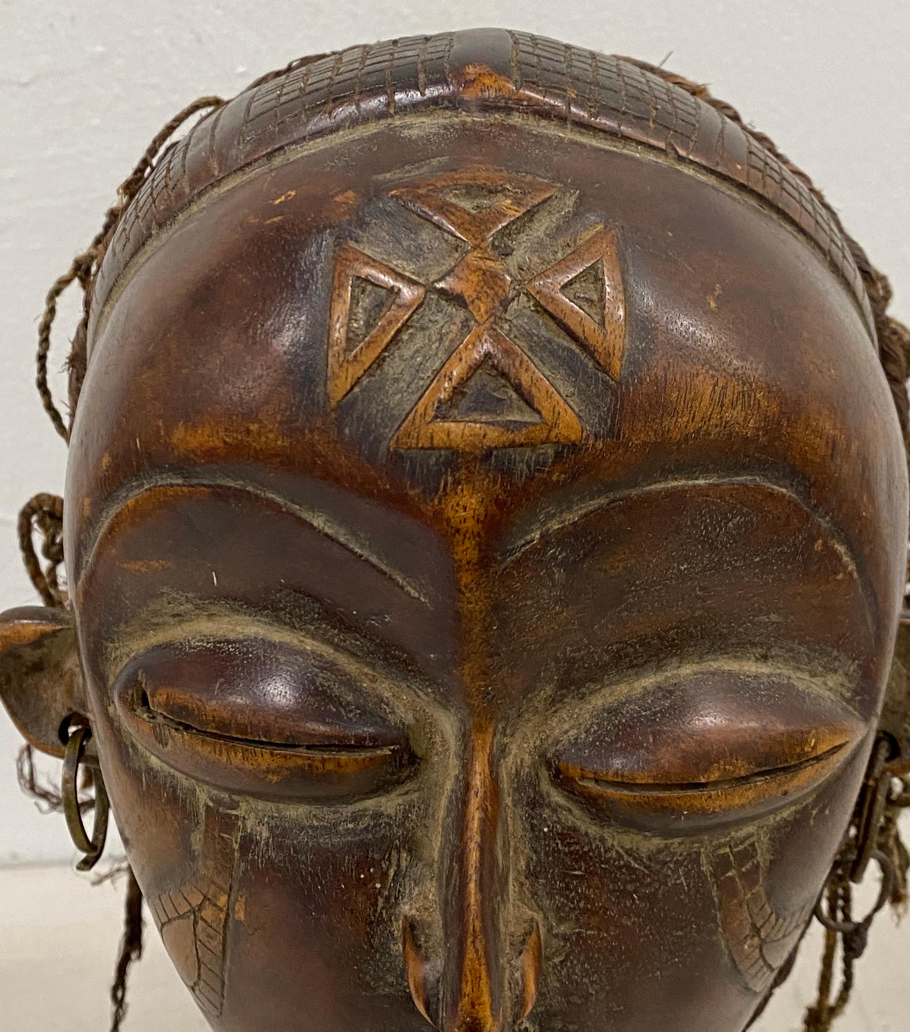 Mid 20th century hand carved African tribal mask.

Fine old school wooden African Tribal mask

Hand carved portrait with natural fiber hair

Measures: 8