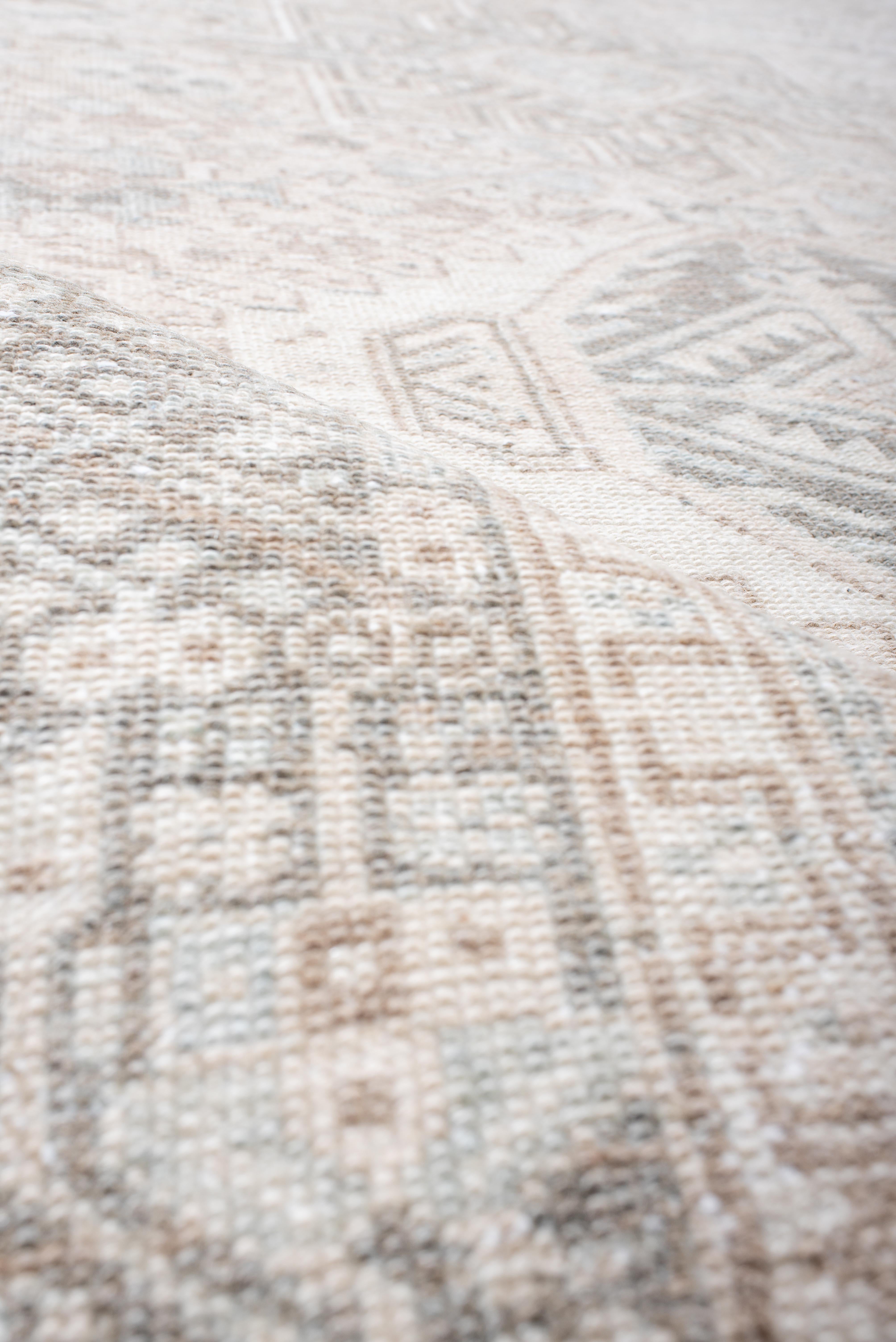 Tejida en la región de Karaja, en el noroeste de Irán, a mediados del siglo XX, esta alfombra presenta una rítmica cadena de tres medallones angulares en forma de diamante, cada uno enmarcado por almenas escalonadas y repleto de estilizados motivos