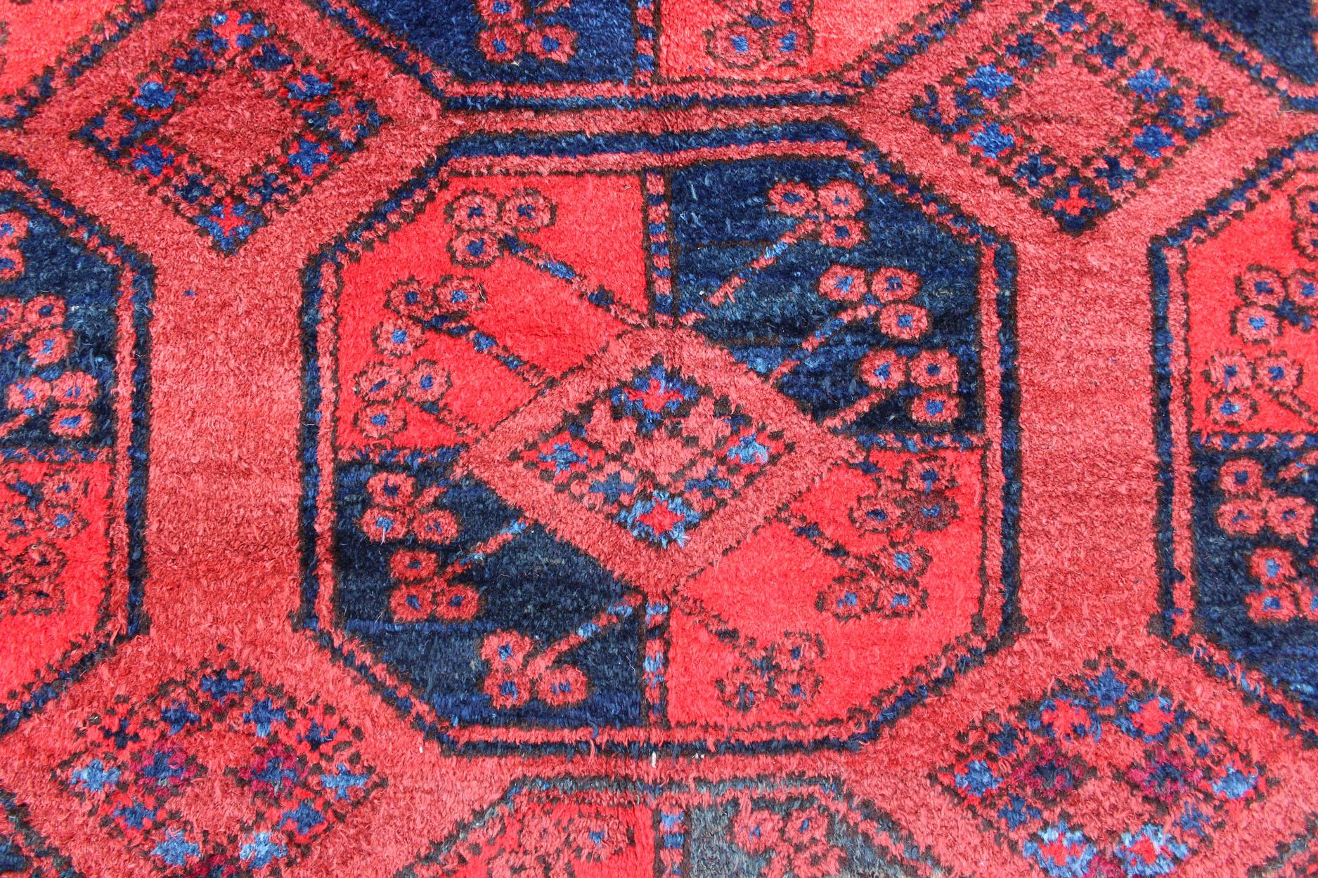 Tapis de taille moyenne noué à la main avec un fond rouge aux accents bleu marine, encadré d'une bordure complexe et d'un motif de Gul à l'intérieur du champ. Circa 1940, Turkomen sub géométrique, Keivan Woven Arts, tapis  Mesure 7'3 x 10'4