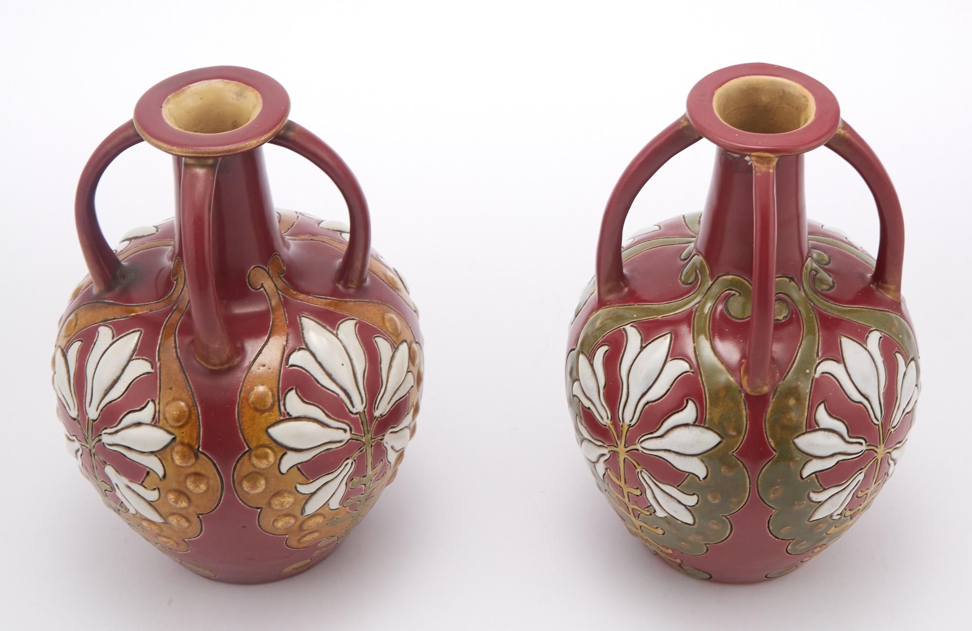 Plongez votre environnement dans le charme du milieu du XXe siècle avec notre paire de vases décoratifs en poterie peints à la main. Artistics, chaque vase est doté d'un col en forme de bouteille et de quatre anses latérales, ce qui ajoute une