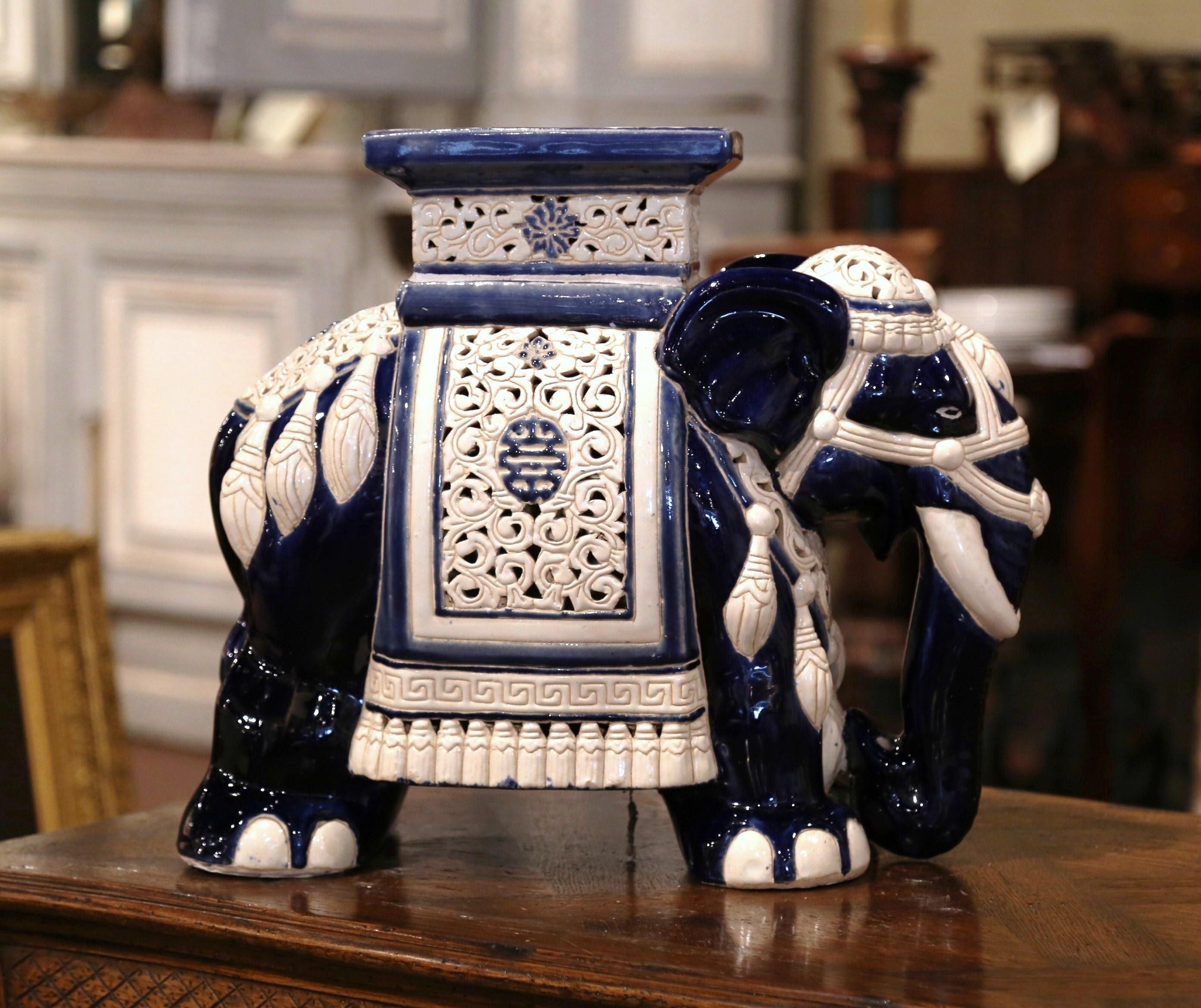 This interesting, porcelain garden seat was found in France. Crafted, circa 1950, the faience seating is in the shape of an elephant, which is heavily decorated in oriental finery. The mammal has a rectangular seat at the top, and is hand painted in