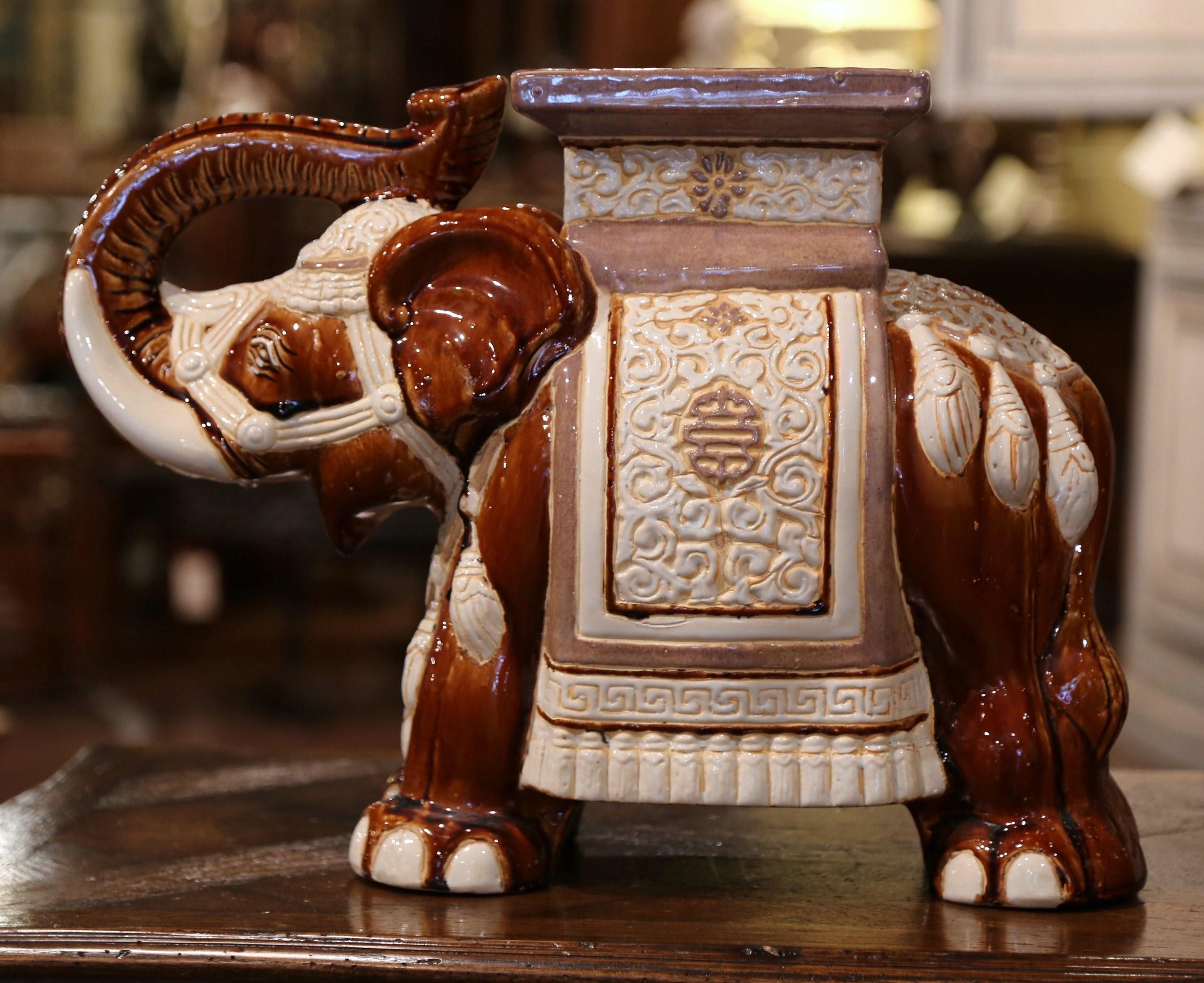 This interesting, vintage porcelain garden seat was found in France. Crafted circa 1960, the ceramic seating shaped as an elephant with his trunk raised (good luck sign in Asia), is heavily decorated in oriental finery, the colorful mammal has a