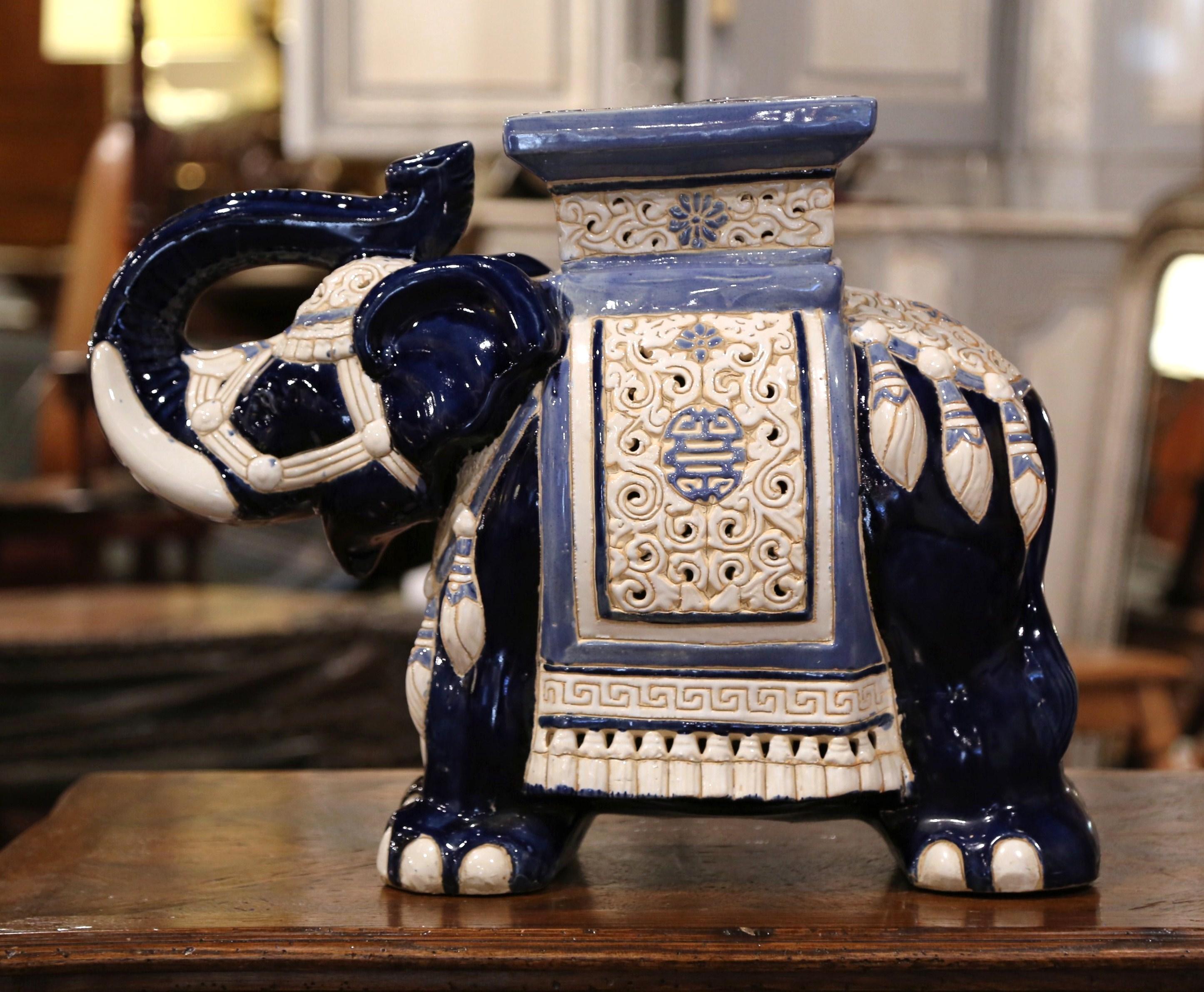 This interesting, vintage porcelain garden seat was found in France. Crafted circa 1960, the ceramic seating shaped as an elephant with his trunk raised (good luck sign in Asia), is heavily decorated in oriental finery; the colorful mammal has a