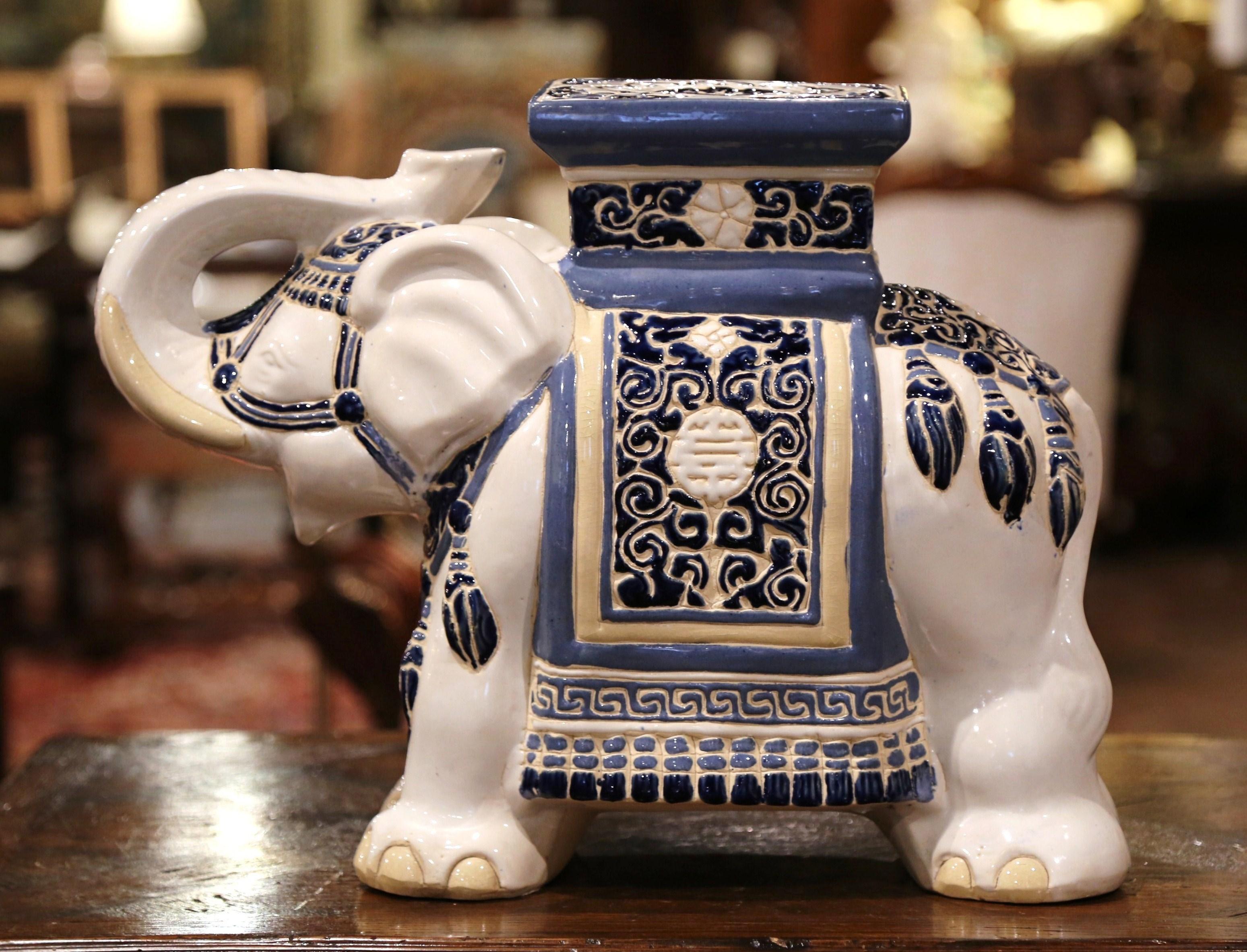 This interesting, vintage porcelain garden seat was found in France. Crafted circa 1960, the ceramic seating shaped as an elephant with his trunk raised (good luck sign in Asia), is heavily decorated in oriental finery, the colorful mammal has a