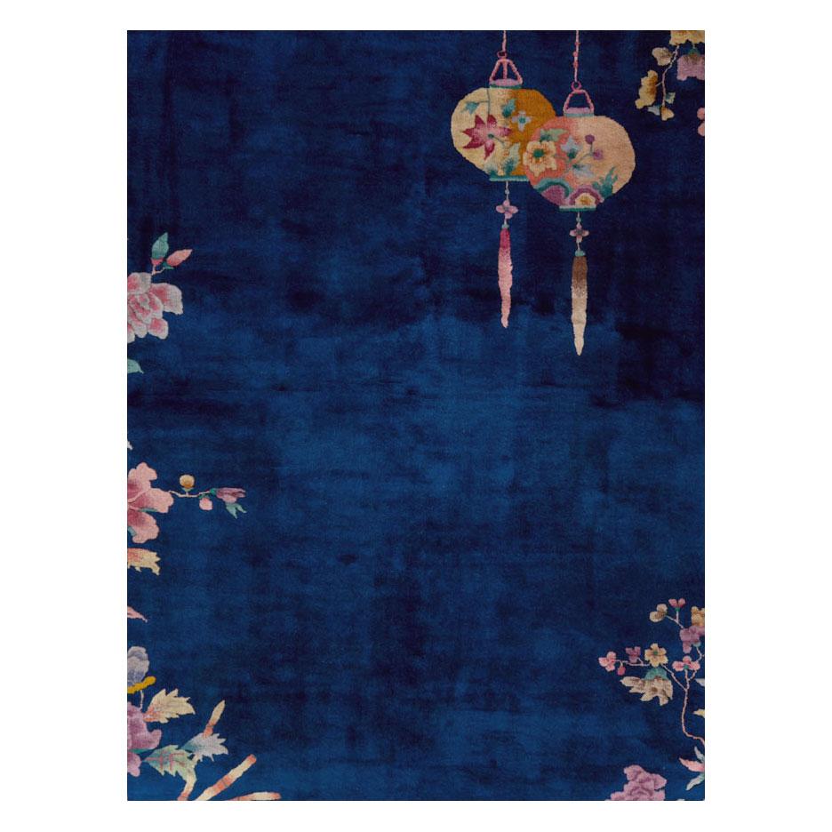 Two Chinese lanterns hang from flowering branches above over a blue field on this vintage Chinese Art Deco room size carpet handmade during the mid-20th century.

Measures: 8' 10