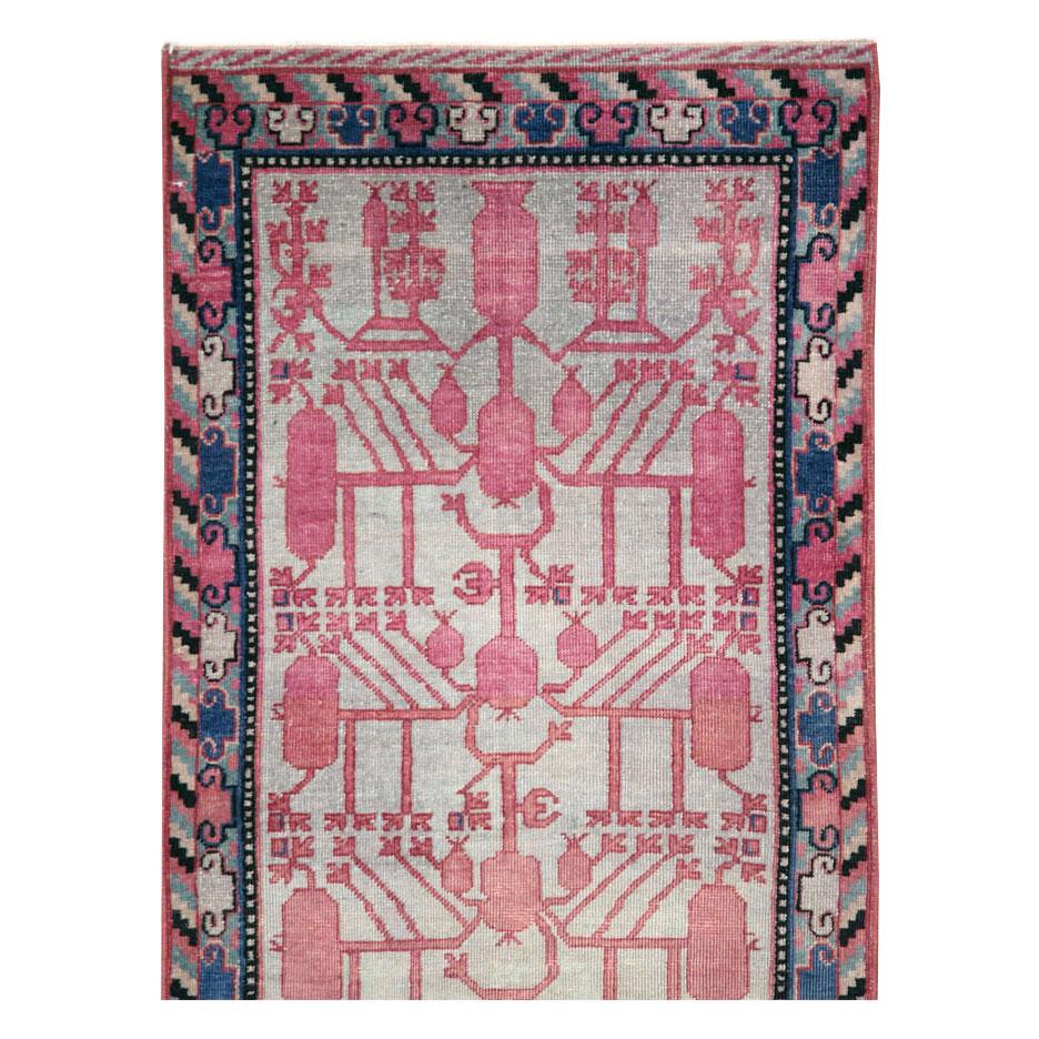 A vintage East Turkestan Khotan rug in runner format with a pomegranate design handmade during the mid-20th century.

Measures: 2' 2