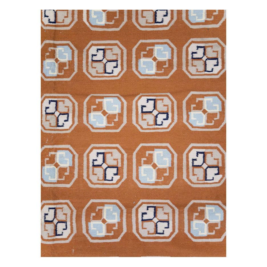A vintage Indian Dhurrie flat-woven large room size carpet handmade during the mid-20th century. The spaced out all-over design of Holbein Octagons fills the terracotta field. The geometric border is finished with a dark blue edging.

Measures: