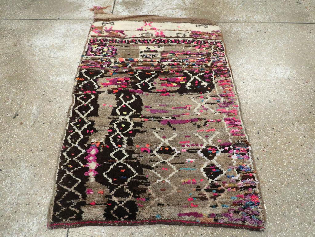 Ein moderner türkisch-anatolischer Streuteppich, der eindeutig von marokkanischen Azilal- und Boucherouite-Teppichen inspiriert ist und im 21. Jahrhundert handgefertigt wurde.

Maße: 2'8
