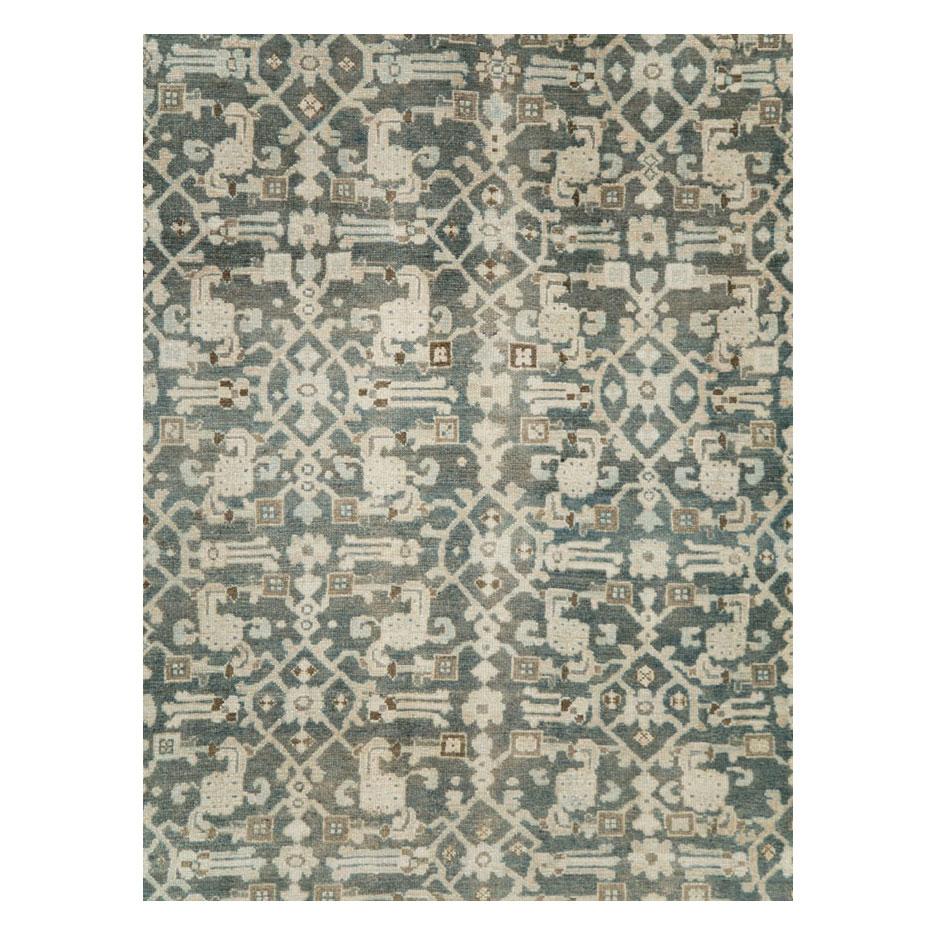 A vintage Persian Malayer accent rug handmade during the mid-20th century utilizing the Classic Herati pattern in cream. The asymmetrical Herati design sits atop a slate grey field that variates with blues and greens. The border has cream and nude