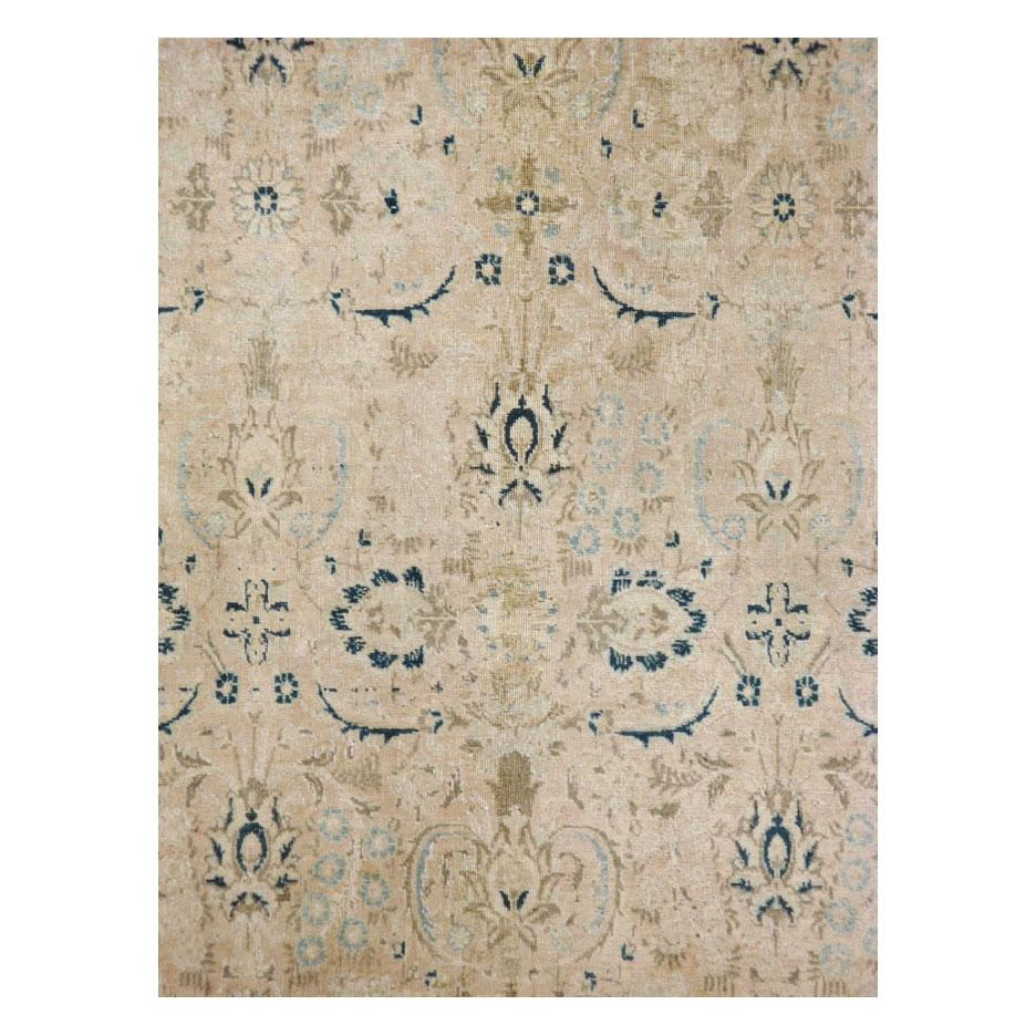 A vintage Persian Tabriz accent rug handmade during the mid-20th century with a field that variates between cream and nude, and a dark greenish-blue border.

Measures: 6' 11