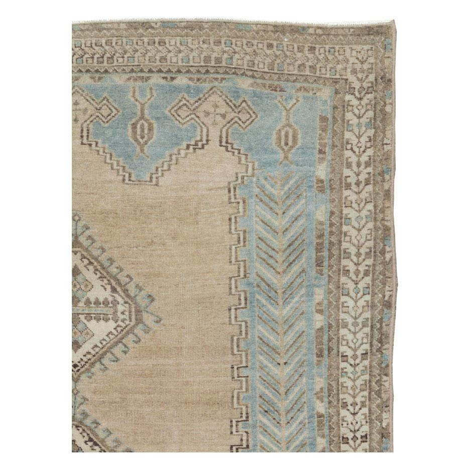 A vintage Persian accent rug handmade by the nomadic Afshar tribe during the mid-20th century with a cream/tan medallion over a light grey field with hints of light blue.

Measures: 4' 10