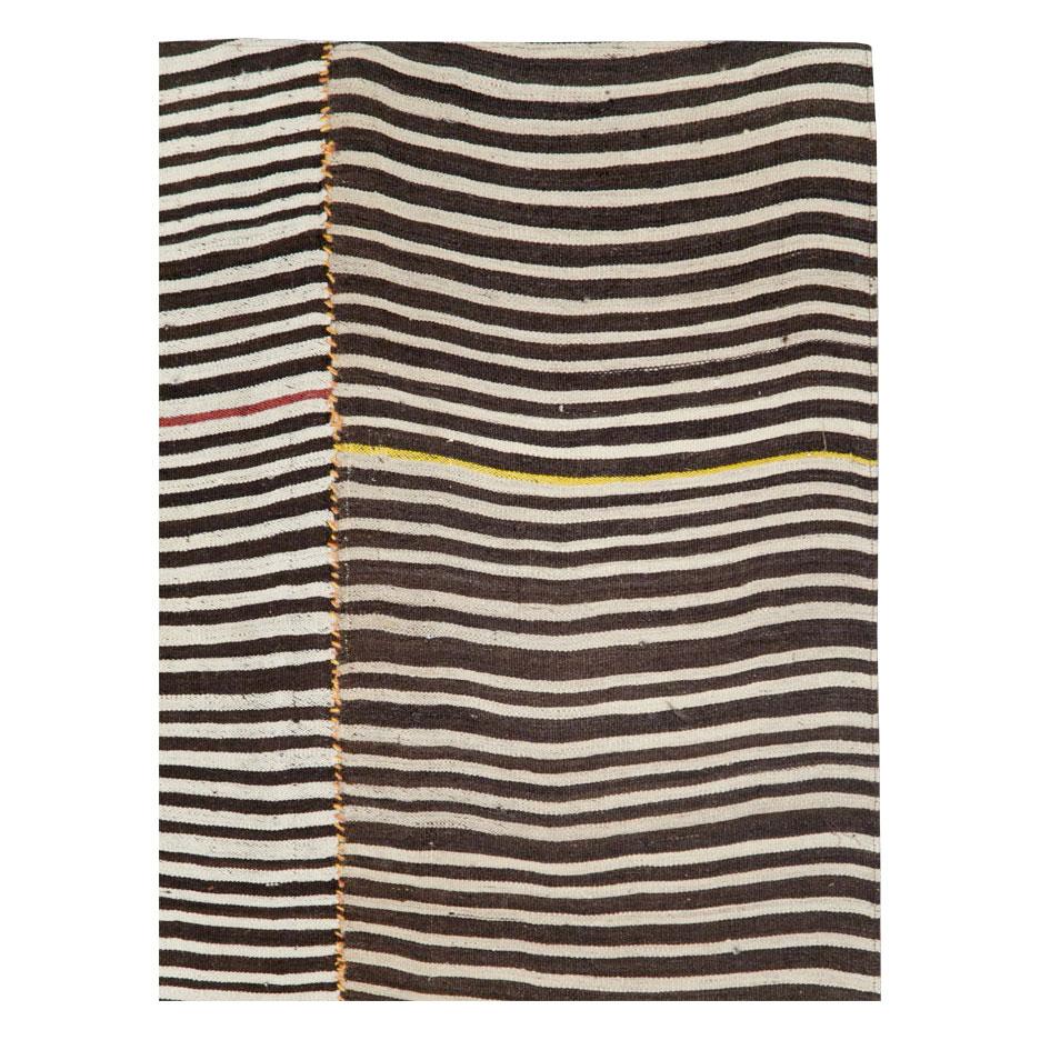 A vintage Persian flat-weave Kilim zebra print small room size accent rug handmade during the mid-20th century. Black and cream stripes, among other shades, create the rustic style that works well with modern farmhouse interiors.

Measures: 5' 7