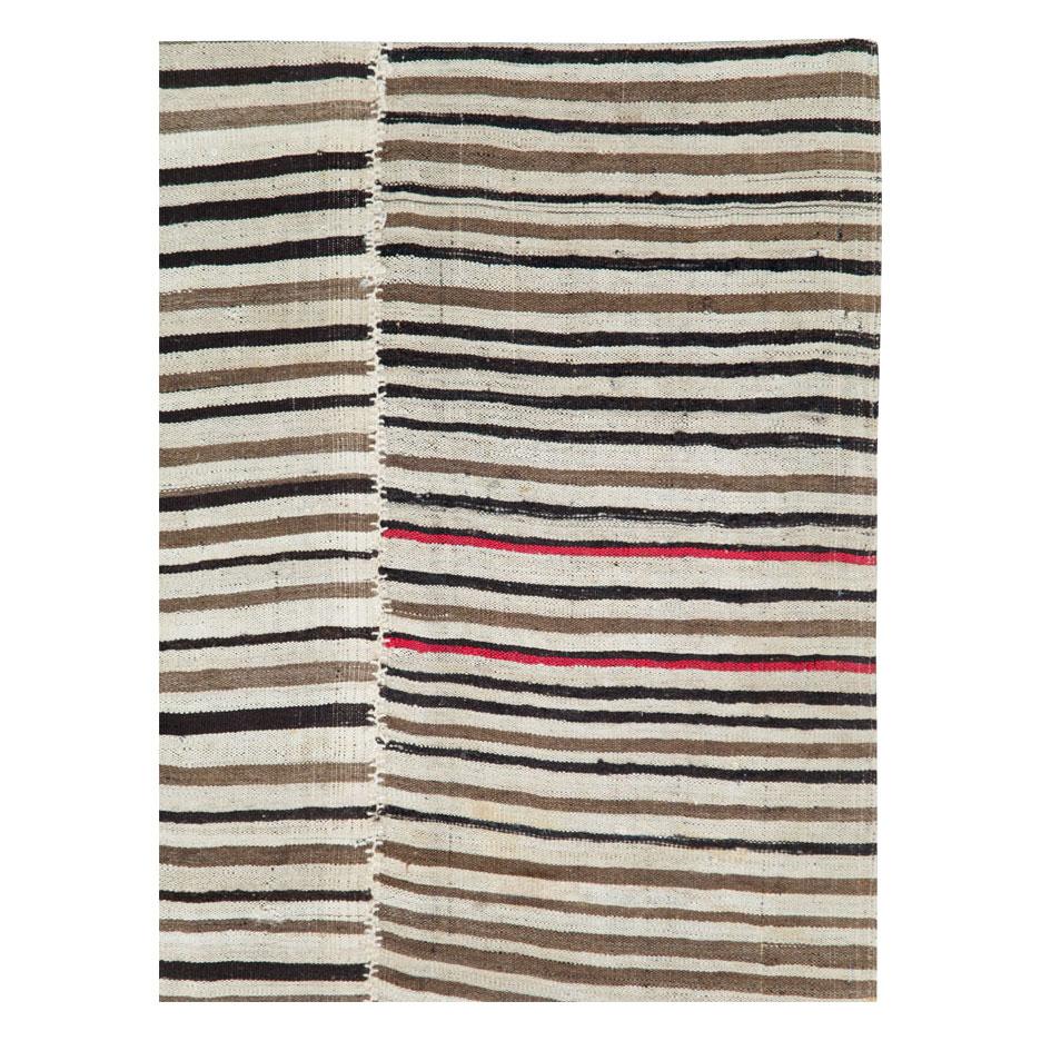 A vintage Persian flat-weave Kilim zebra print small room size accent rug handmade during the mid-20th century. Black and cream stripes, among other shades, create the rustic style that works well with modern farmhouse interiors.

Measures: 5' 1