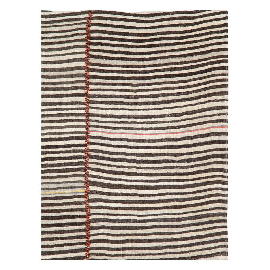 A vintage Persian flat-weave Kilim zebra print small room size accent rug handmade during the mid-20th century. Black, brown, and cream stripes, among other shades, create the rustic style that works well with modern farmhouse