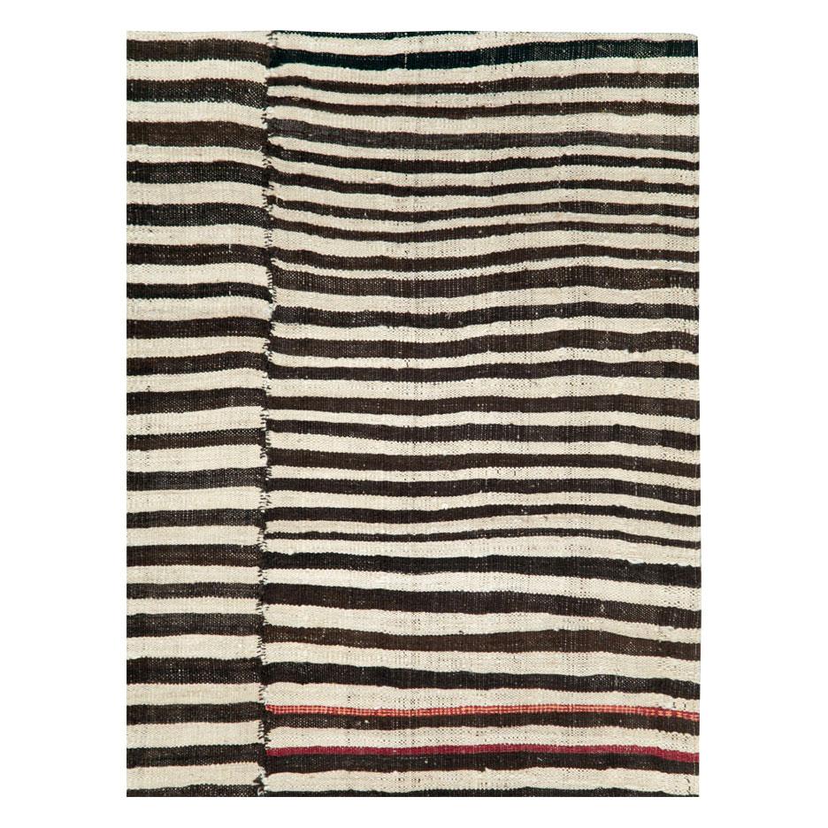 A vintage Persian flat-weave tribal Kilim room size accent rug handmade during the mid-20th century with a zebra print design in ivory and black.

Measures: 5' 7