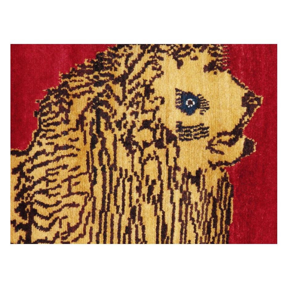 A vintage Persian Gabbeh accent rug handmade during the mid-20th century with a pictorial design of a lion over a plain red field.

Measures: 4'3