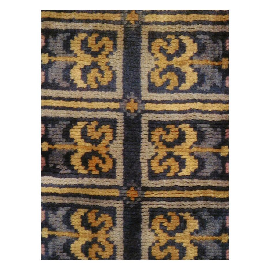 A vintage Spanish rug in runner format in the style and technique of French Savonnerie rugs handmade during the mid-20th century. The design, in shades of gold decorating the dark blue field, was heavily influenced by the 1930s Art Deco