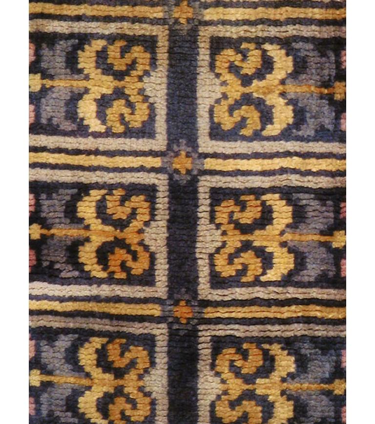 A vintage Spanish rug in runner format in the style and technique of French Savonnerie rugs handmade during the mid-20th century. The design, in shades of gold decorating the dark blue field, was heavily influenced by the 1930s Art Deco