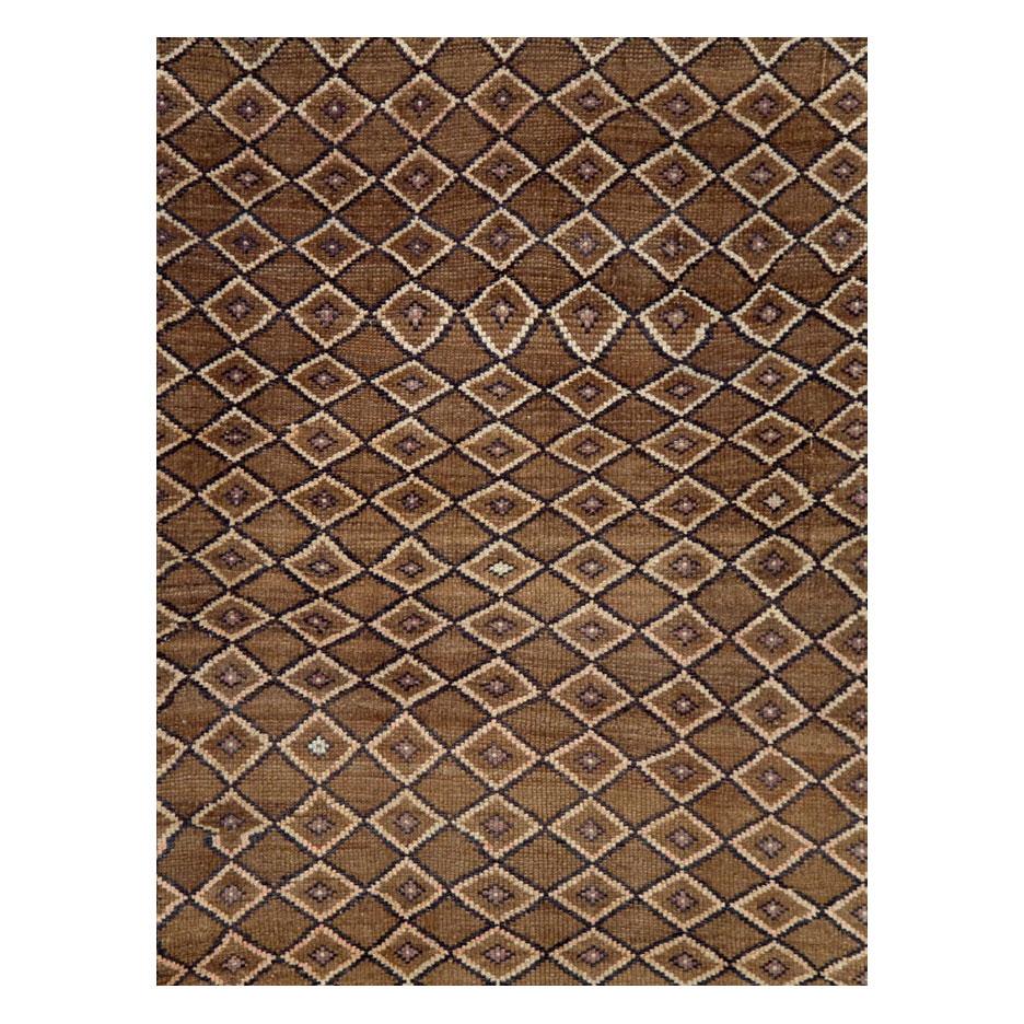 A vintage Turkish Anatolian room size rug handmade during the mid-20th century with a diamond lattice pattern over a brown colored field, and a cream colored border with a dark mauve colored turtle palmette design inspired by Persian