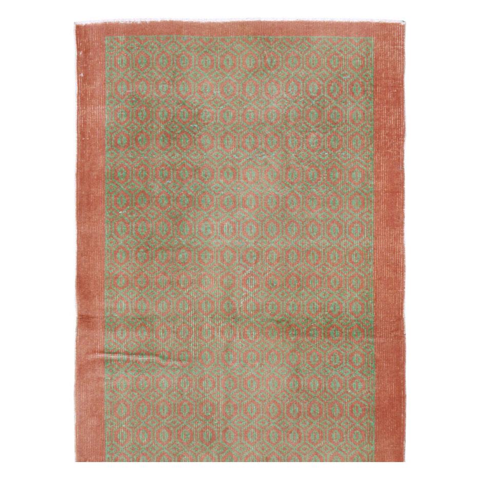 A vintage Turkish Anatolian rug in runner format handmade during the mid-20th century with a contemporary geometric lattice pattern in shades of coral and terracotta over a light green field.

Measures: 2' 6