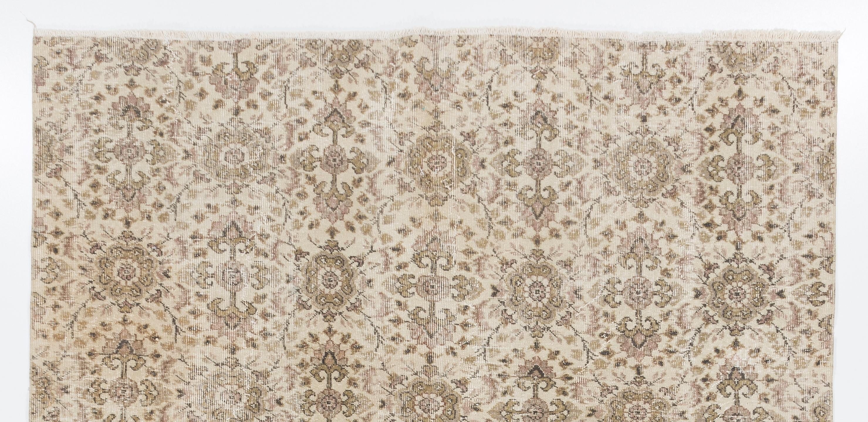 Ce tapis turc vintage. Il a été noué à la main dans les années 1960 et présente un motif floral sur toute sa surface. Poil ras en laine sur une base en coton finement tissé. Robuste et pouvant être utilisé sur une zone à fort trafic, il convient aux