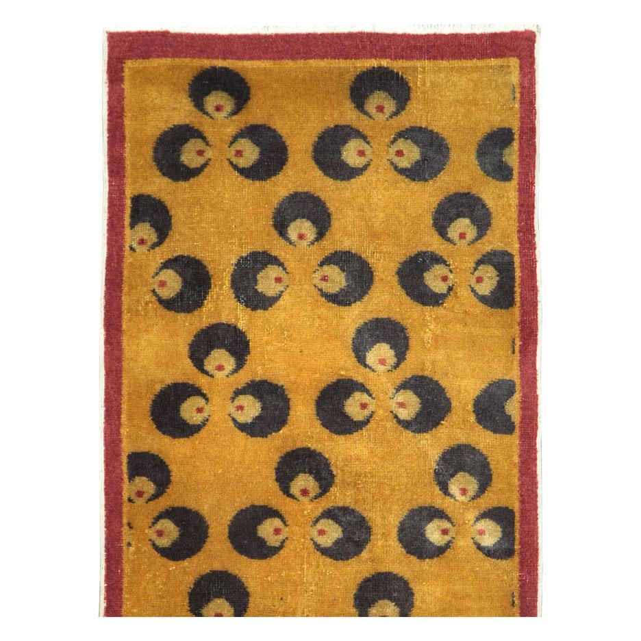 A vintage Turkish Anatolian Art Deco rug handmade during the mid-20th century. The ancient Buddhist Chintamani (often spelled Cintamani) design in a very dark midnight blue sits atop a goldenrod field and enclosed by a thin solid maroon border.