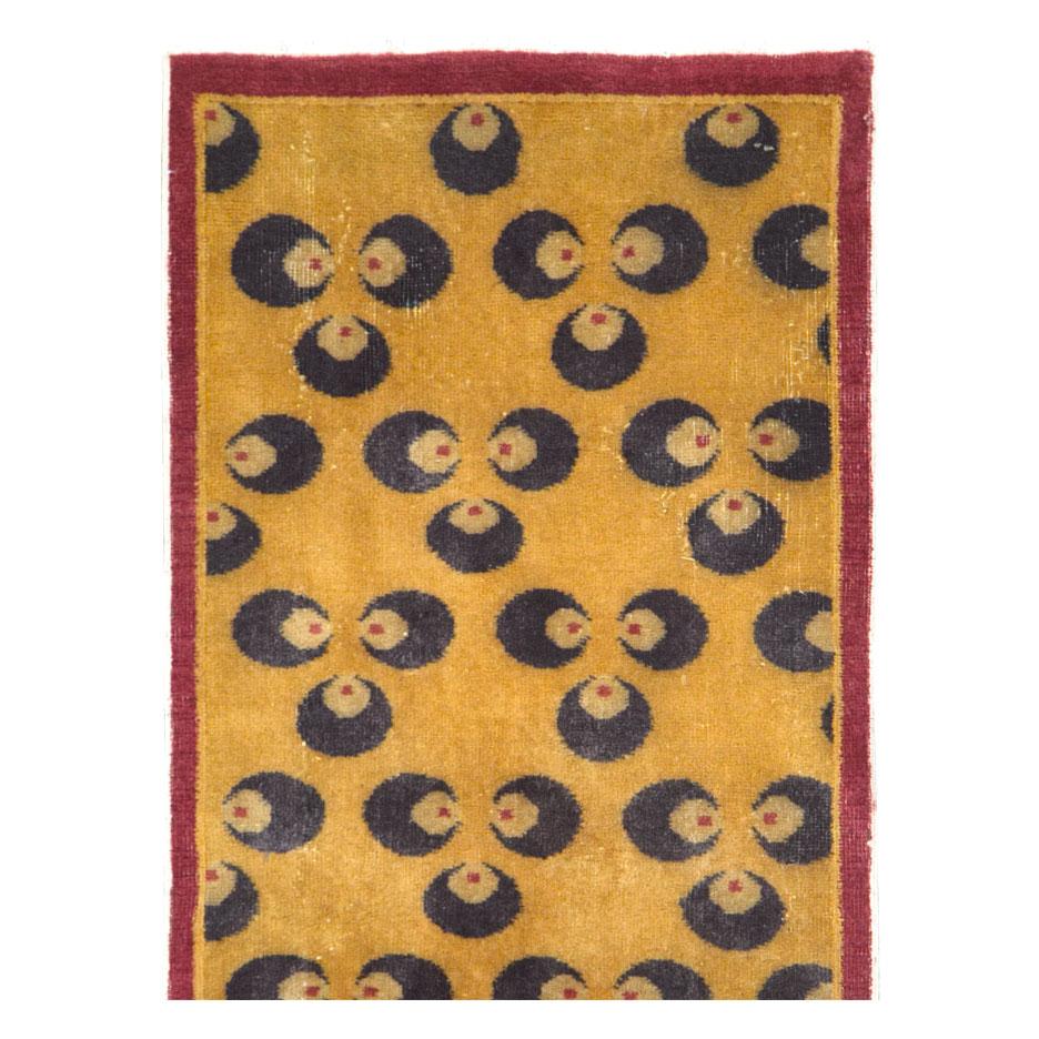 A vintage Turkish Anatolian Art Deco rug handmade during the mid-20th century. The ancient Buddhist Chintamani (often spelled Cintamani) design in a very dark midnight blue sits atop a goldenrod field and enclosed by a thin solid maroon border.