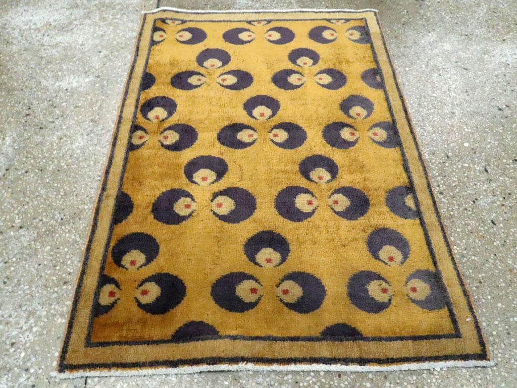 A vintage Turkish Anatolian Art Deco throw rug handmade during the mid-20th century with a goldenrod field and border. The Cintamni pattern of 3 stones is in dark purple-grey with red dots.

Measures: 2' 3