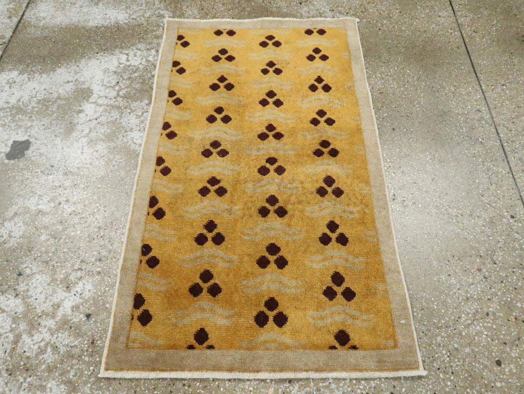 A vintage Turkish Anatolian Art Deco throw rug handmade during the mid-20th century with a goldenrod field and silver-grey border. The Cintamni pattern of 3 stones is in dark brown almost reading black.

Measures: 2' 1