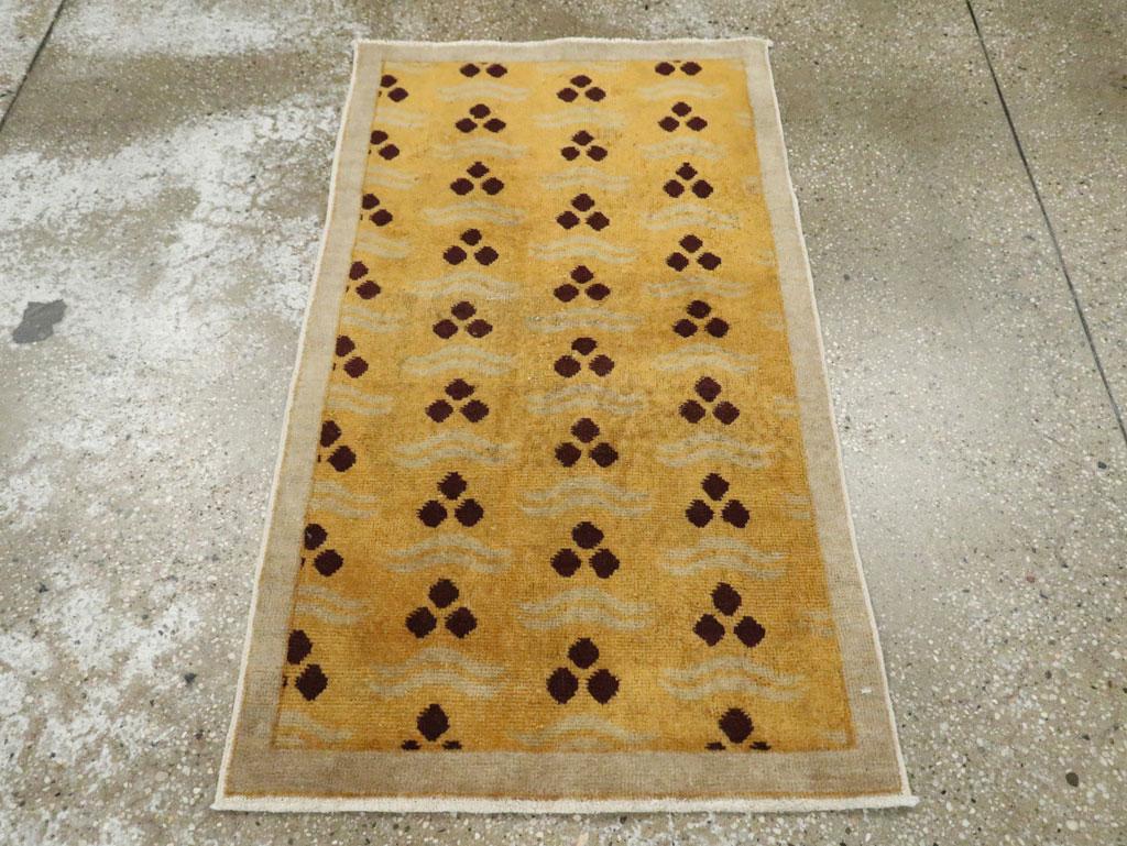 Tapis jetable Art déco turc anatolien vintage, fabriqué à la main au milieu du 20e siècle, avec un champ de verge d'or et une bordure gris argenté. Le motif Cintamni de 3 pierres est en marron foncé, presque du noir.

Mesures : 2' 1