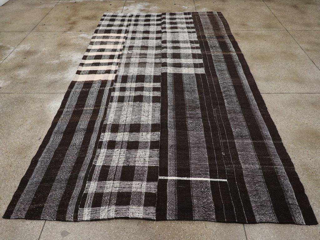 A vintage Turkish flatweave Kilim long and narrow room size carpet in charcoal black, grey, and cream-white, handmade during the mid-20th century.

Measures: 7' 5