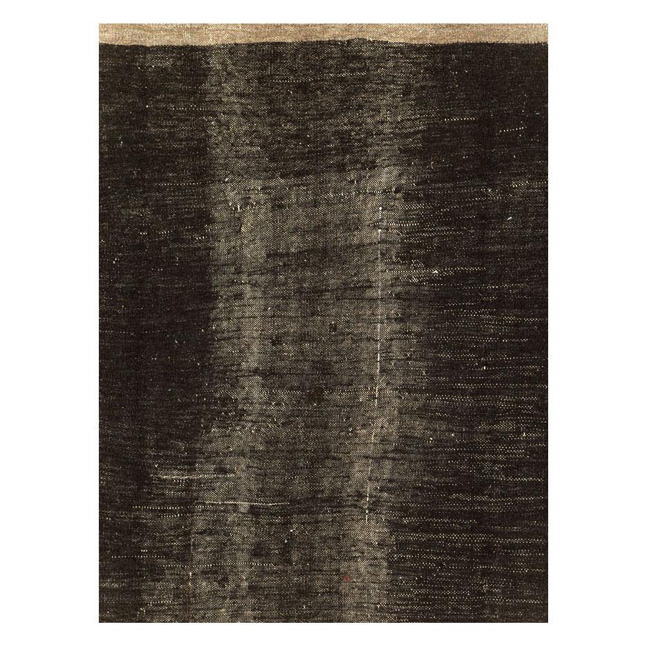A vintage Turkish flatweave Kilim room size carpet handmade during the mid-20th century in shades of charcoal black, light brown, and white.

Measures: 7' 10