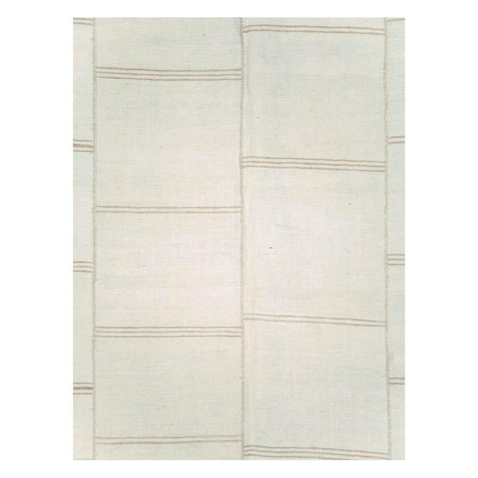 A vintage Turkish flat-weave Kilim room size carpet handmade during the mid-20th century. 6 columns of offset dark beige horizontal lines over a white or cream linen colored background compose this soft neutral toned rug.

Measures: 8' 3