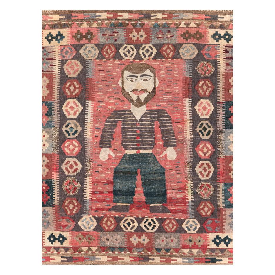 A vintage Turkish flatweave Kilim throw rug in square format handmade during the mid-20th century with a pictorial design of a cartoon-like male figure.

Measures: 3' 1