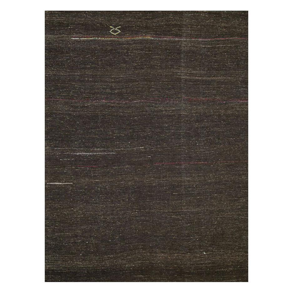 Ein türkischer Flachgewebe-Kilim-Akzentteppich aus der Mitte des 20. Jahrhunderts mit einer Stammesästhetik in Braun mit nur einer schwachen Linie in Grün und Rosa gegen den oberen Teil des Teppichs.

Maße: 6' 8
