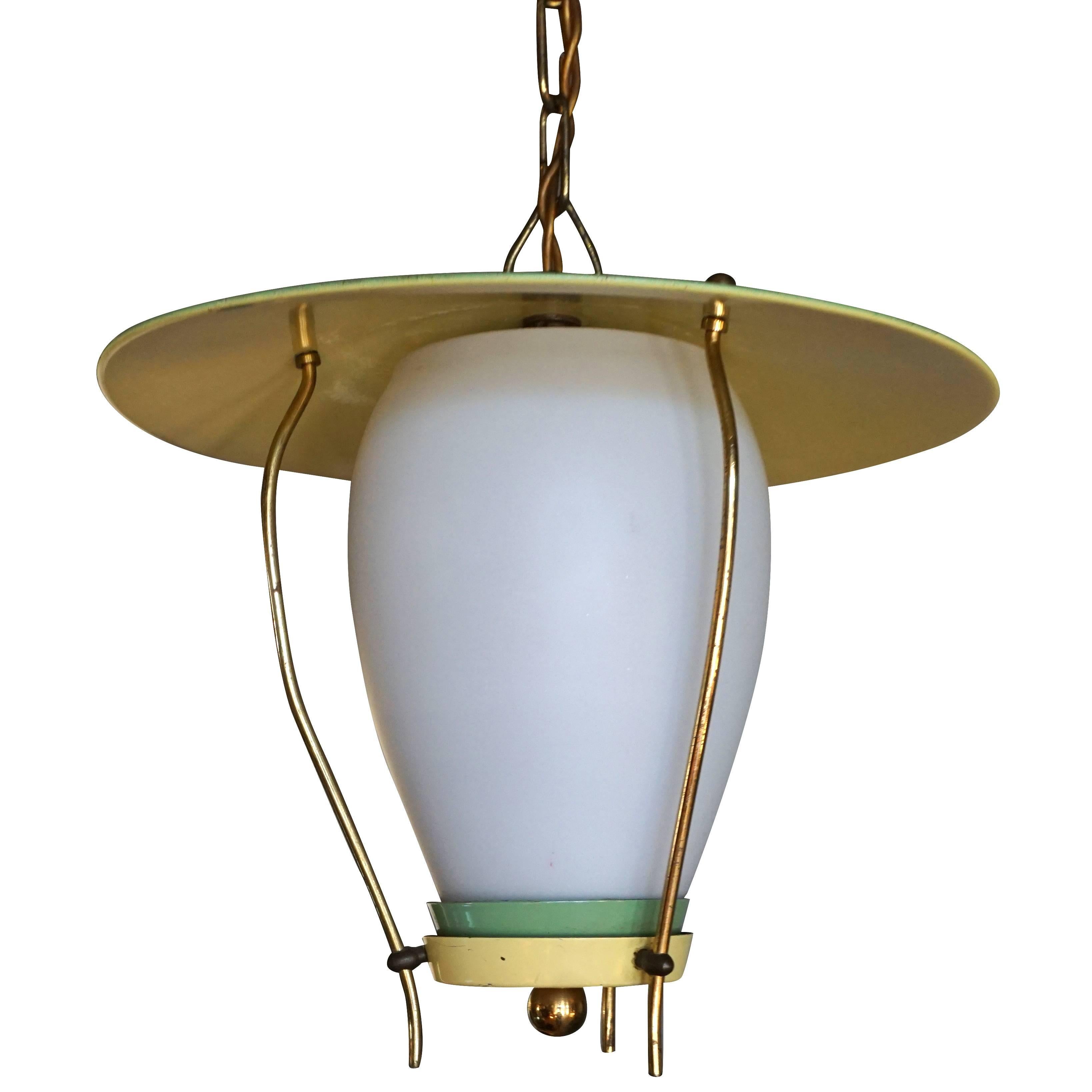 A small green, vintage Mid-Century Modern Italian hanging lantern, ceiling light made of hand crafted brass and metal with a half frosted opaline glass shade, featuring a one light socket, produced by Stilnovo in good condition. The wires have been