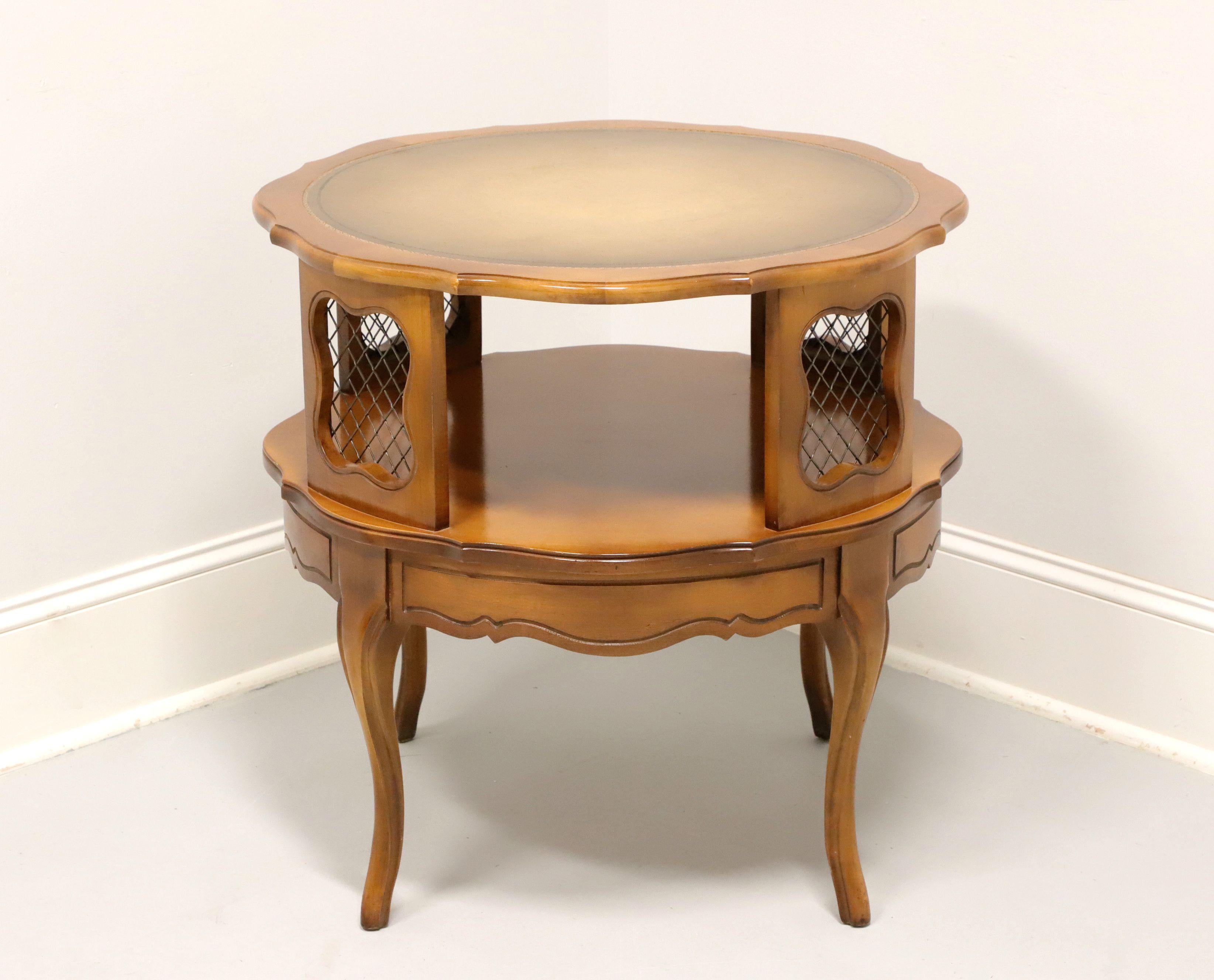 A French Provincial style round leather top accent table, unbranded, similar quality to Weiman. Hardwood, embossed leather top with scalloped edges, four panels with encased brass mesh support the top, undertier shelf, carved apron, and curved legs.