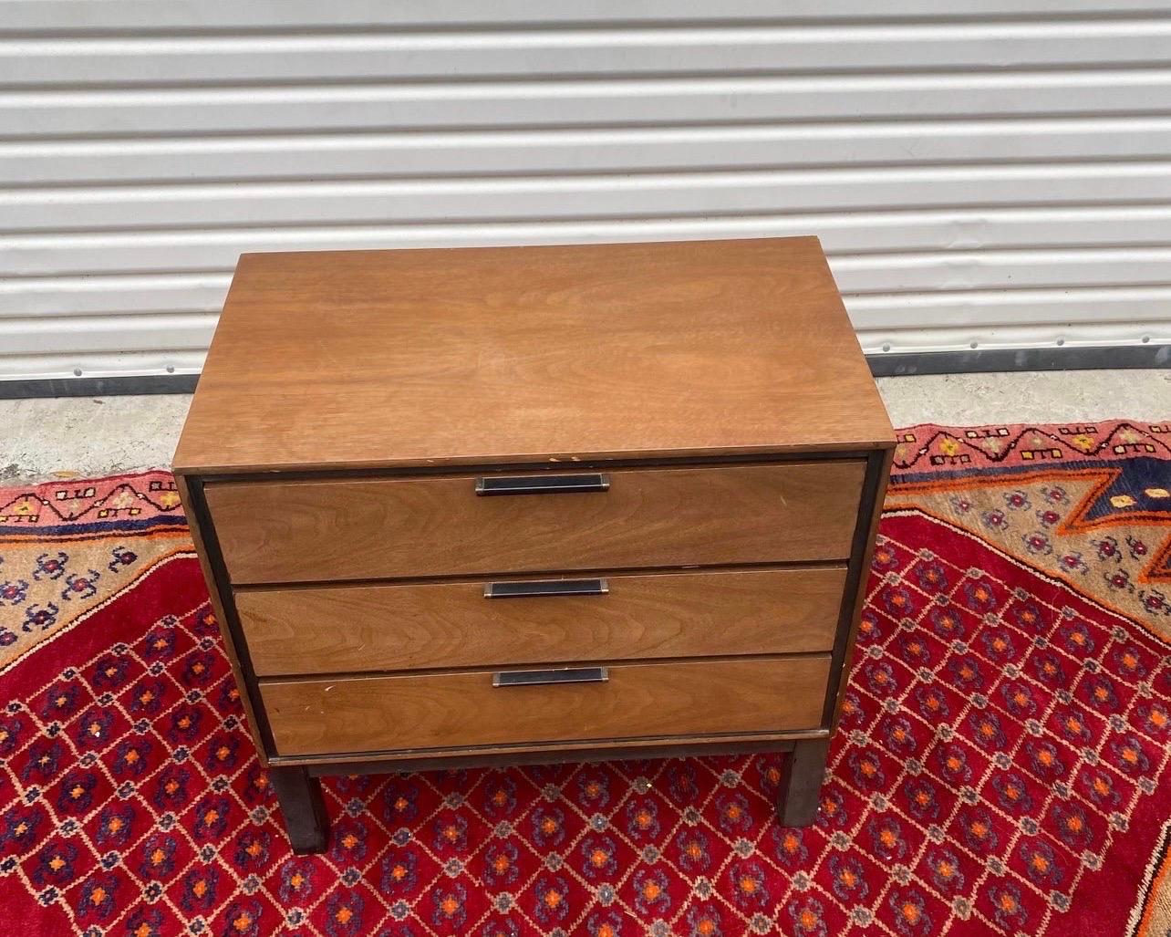 A fantastic 3 drawer nightstand/chest cased in walnut with ebonized legs and drawer pulls. In the manner of Harvey Probber.